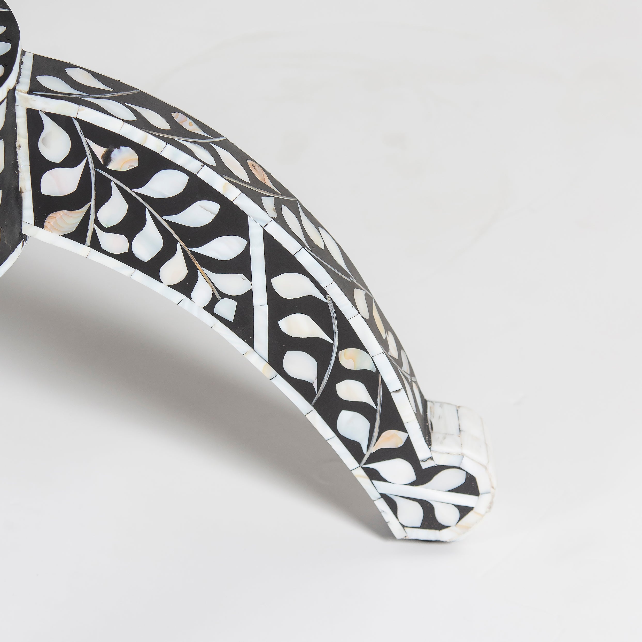 Handcrafted Iris dining table featuring black mother of pearl inlay with a round top and sculptural pedestal base.