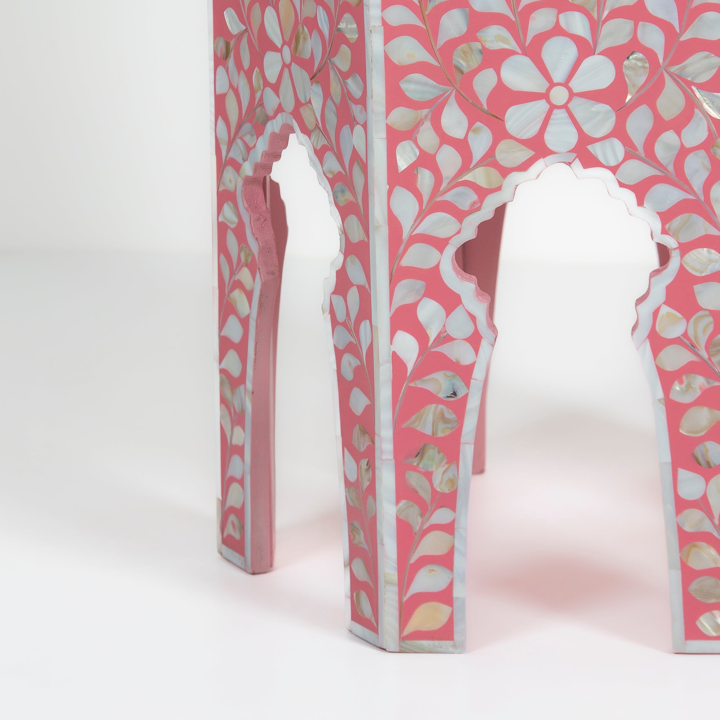 Handcrafted Iris side table featuring pink mother of pearl inlay with a hexagonal silhouette, floral detailing, and arched legs.
