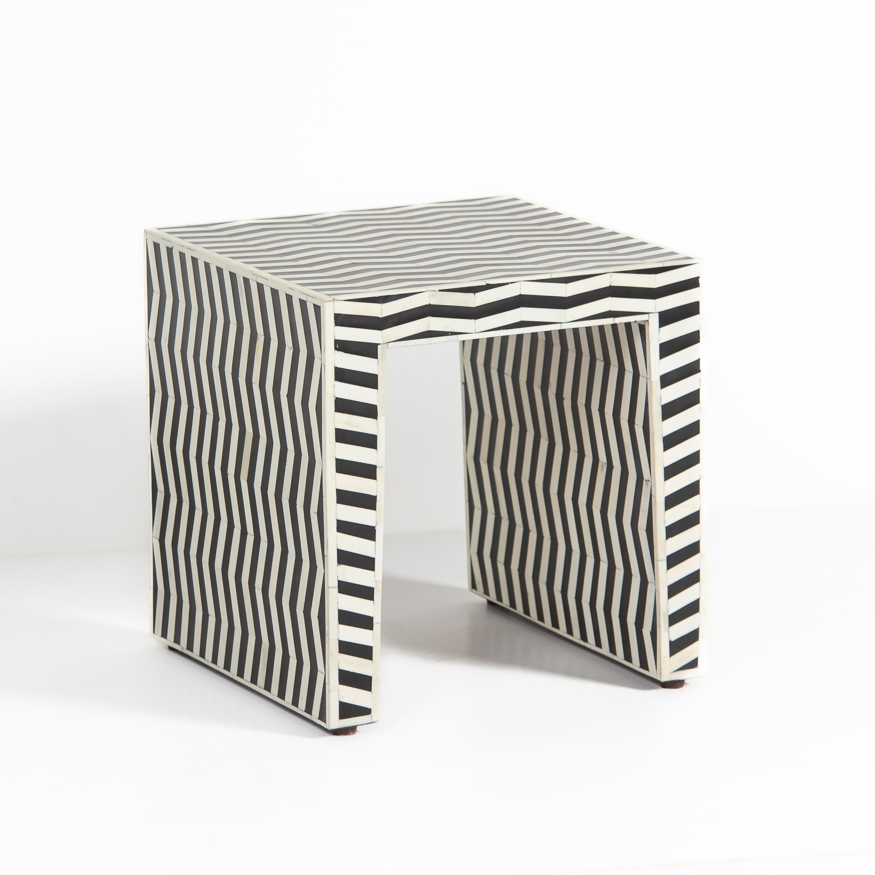 Handcrafted Isra side table featuring black bone inlay with geometric striped detailing and a compact cubic form.