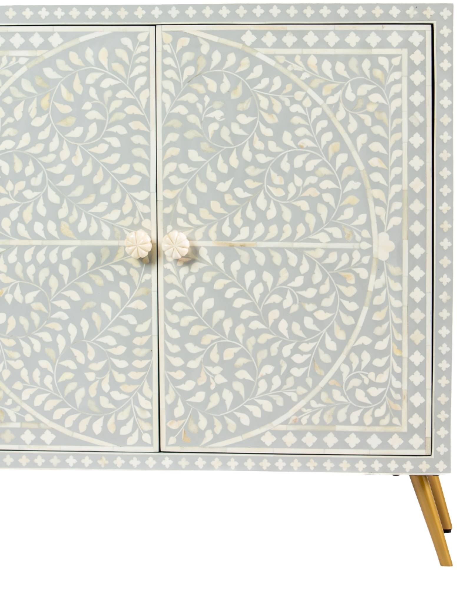 Grey bone inlay cabinet with floral vine pattern, brass legs, and carved bone knobs, handcrafted with spacious storage and artisanal charm.