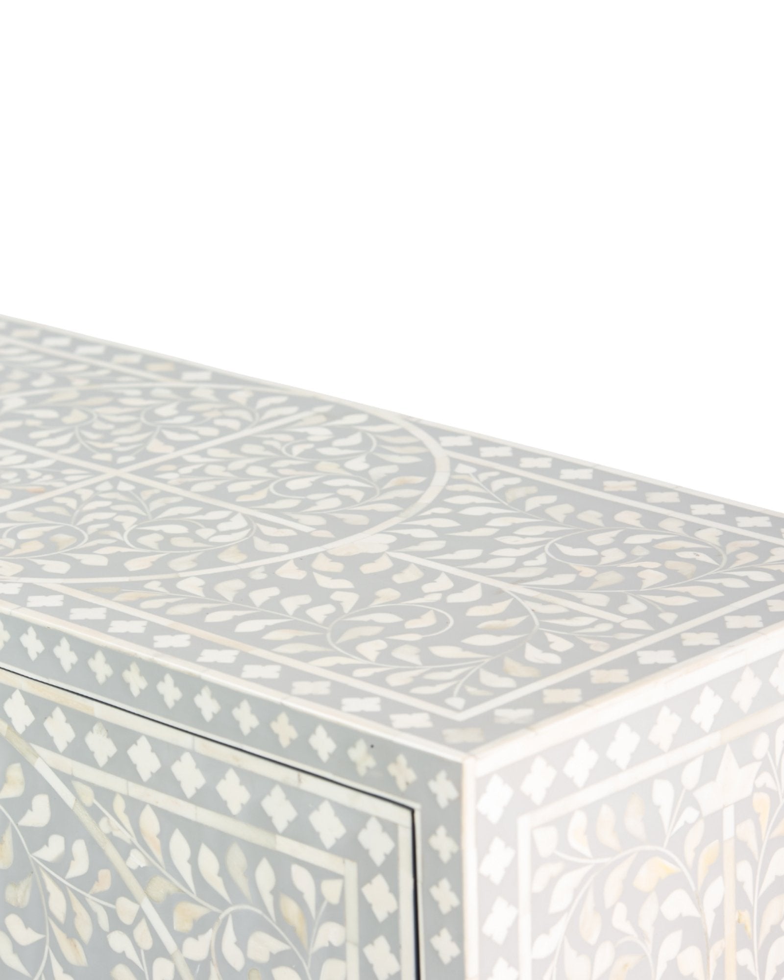 Grey bone inlay cabinet with floral vine pattern, brass legs, and carved bone knobs, handcrafted with spacious storage and artisanal charm.