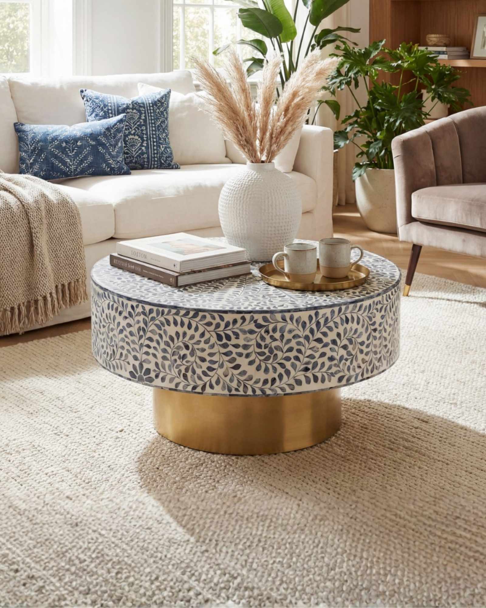 Handcrafted Jade coffee table featuring intricate blue bone inlay detailing with a round silhouette and brushed brass base.