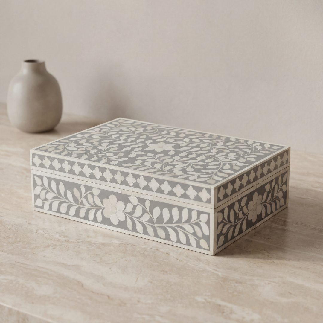 A soft grey decorative box crafted in bone inlay, combining subtle tones with intricate floral detailing.
