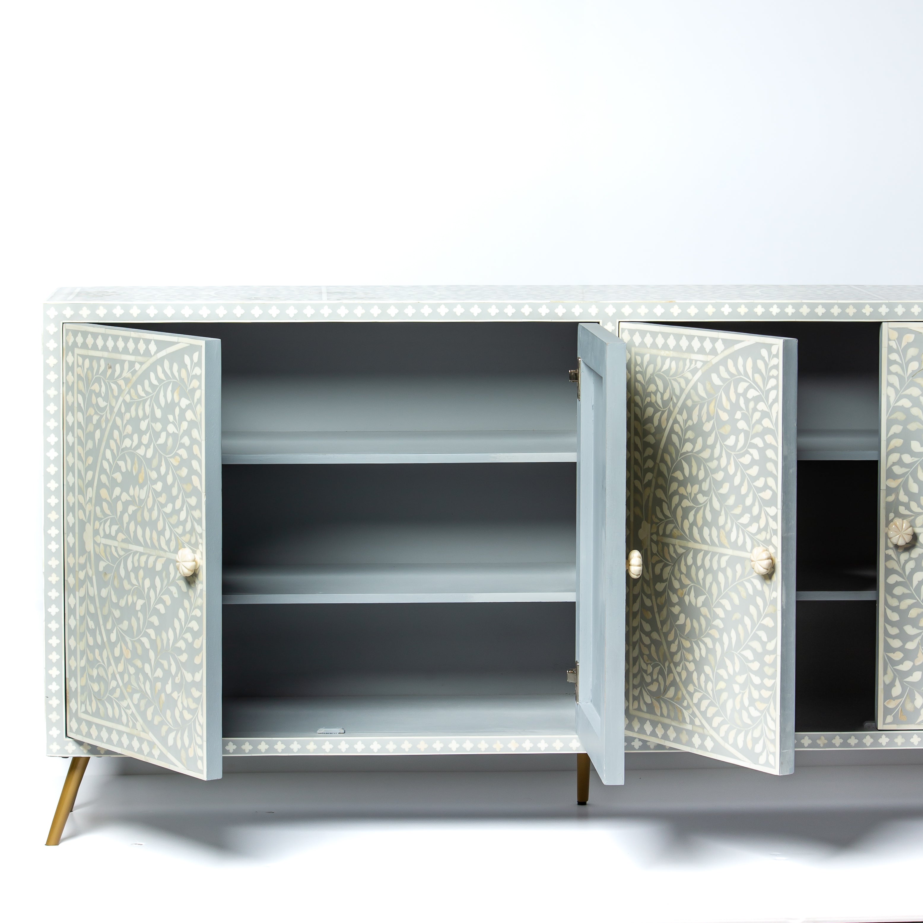 Grey bone inlay cabinet with floral vine pattern, brass legs, and carved bone knobs, handcrafted with spacious storage and artisanal charm.