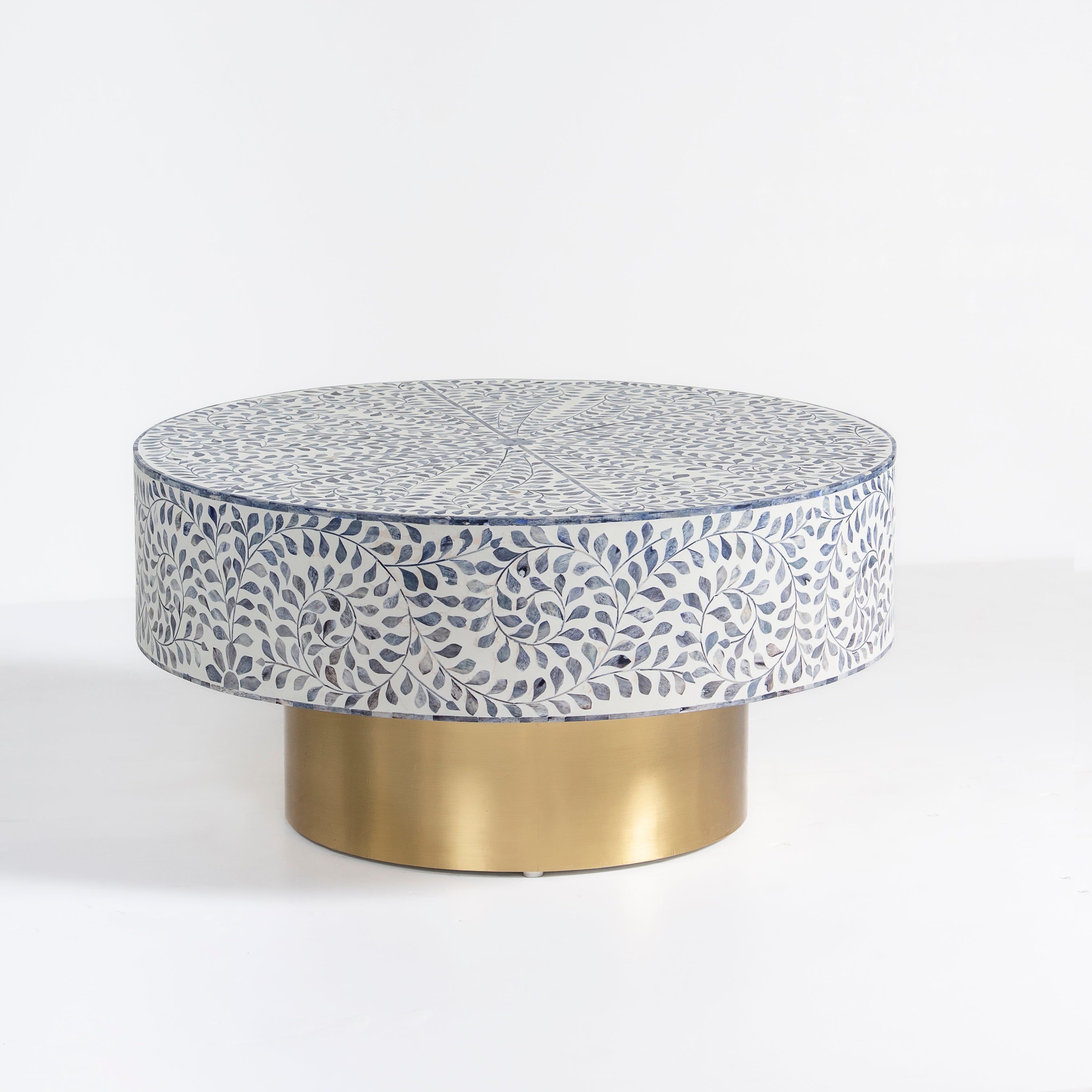 Handcrafted Jade coffee table featuring intricate blue bone inlay detailing with a round silhouette and brushed brass base.