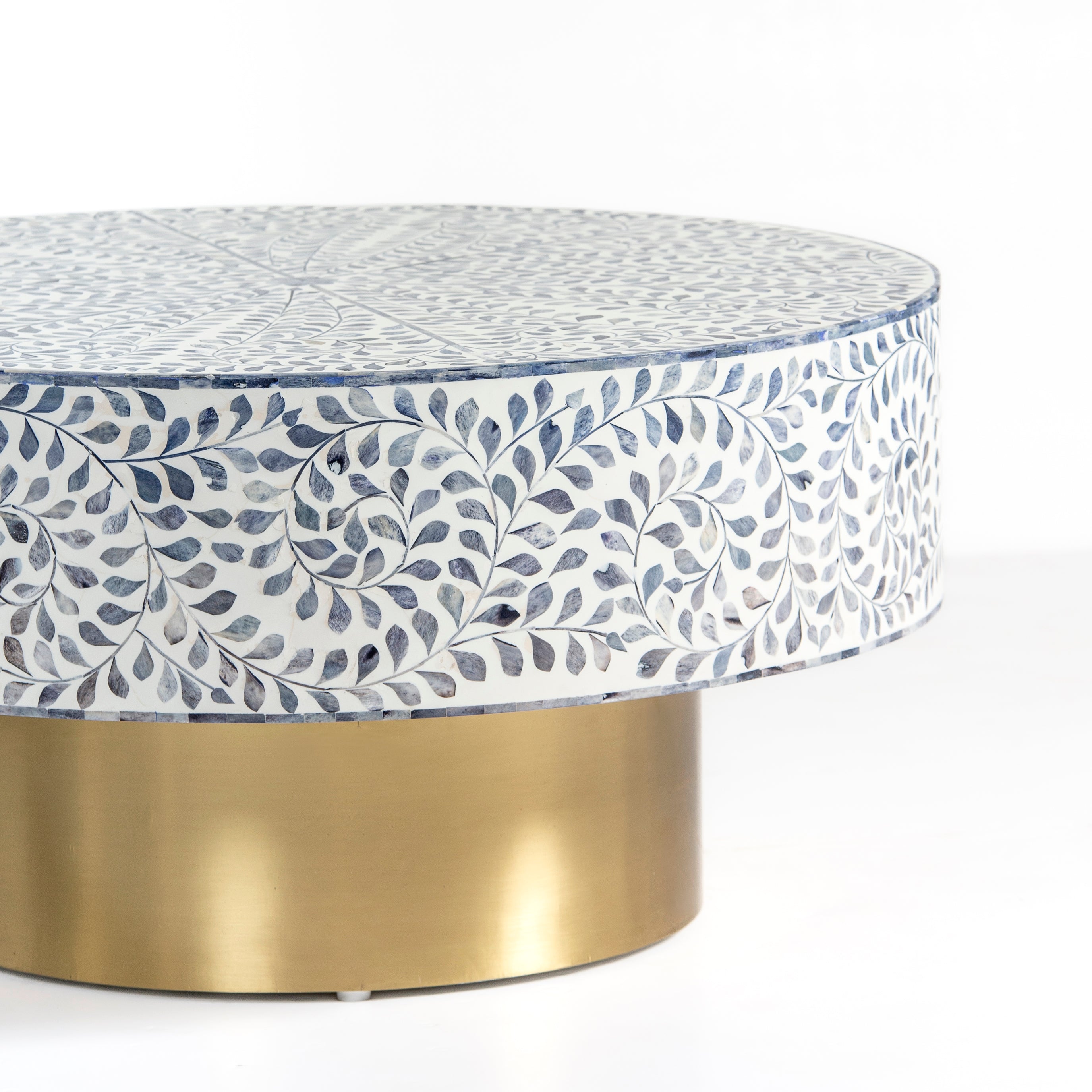 Handcrafted Jade coffee table featuring intricate blue bone inlay detailing with a round silhouette and brushed brass base.