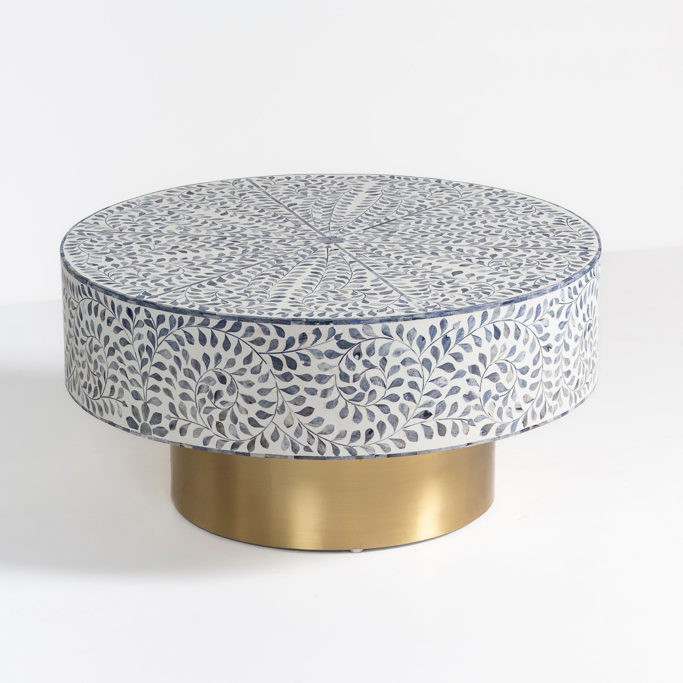 Handcrafted Jade coffee table featuring intricate blue bone inlay detailing with a round silhouette and brushed brass base.