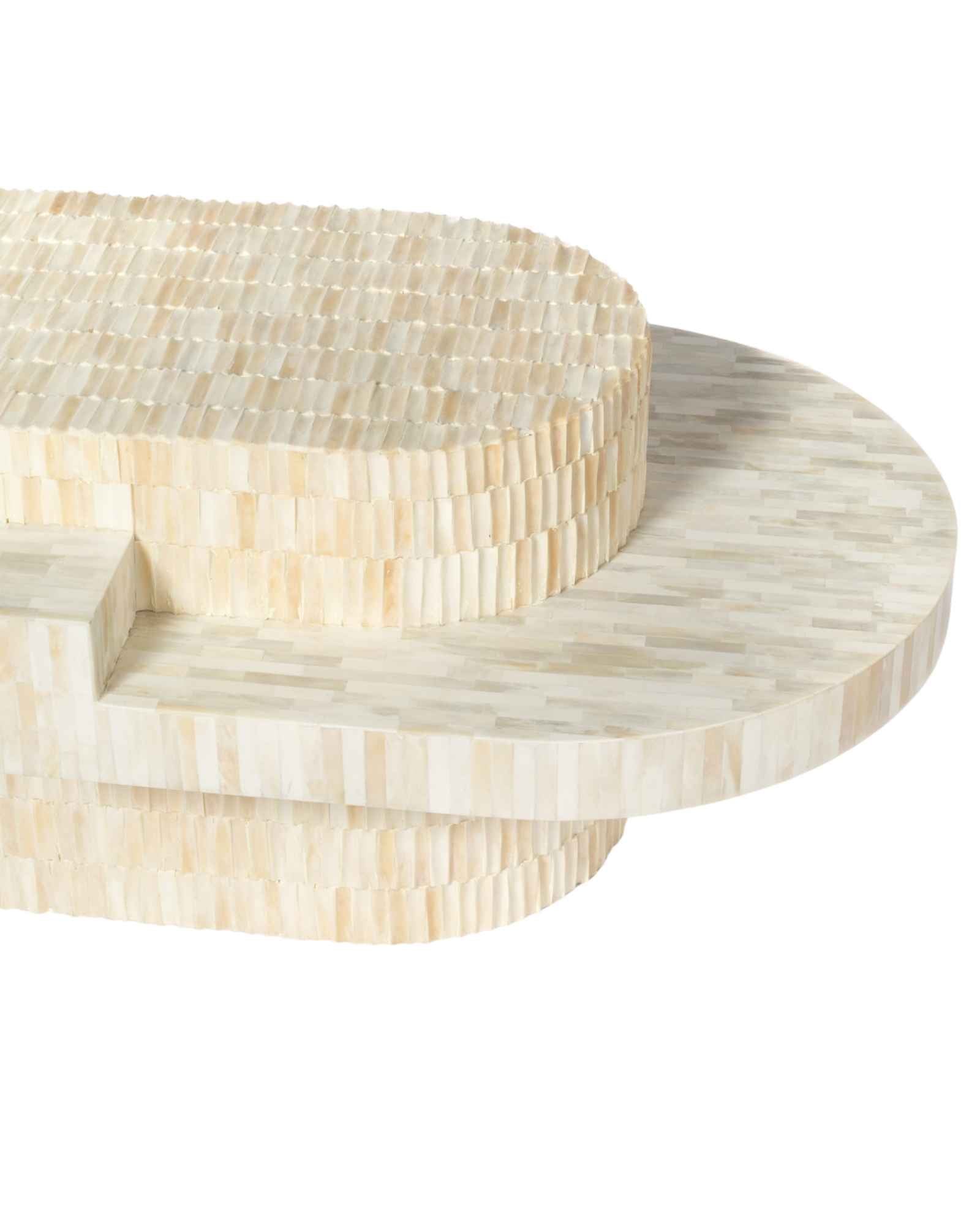 Sculptural bone carved coffee table with layered design in soft neutral tones, handcrafted with curved tiers and textured artisanal detailing.