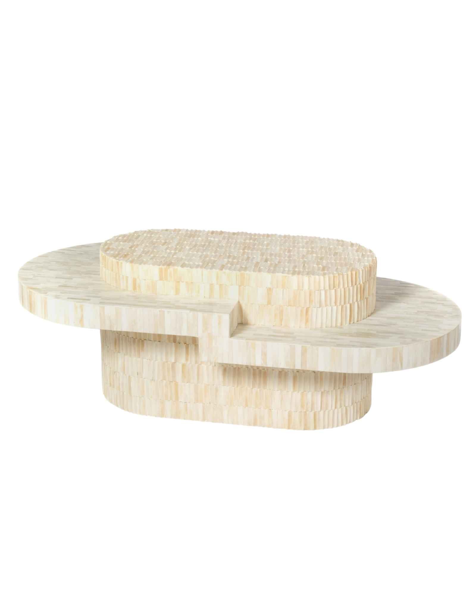 Sculptural bone carved coffee table with layered design in soft neutral tones, handcrafted with curved tiers and textured artisanal detailing.