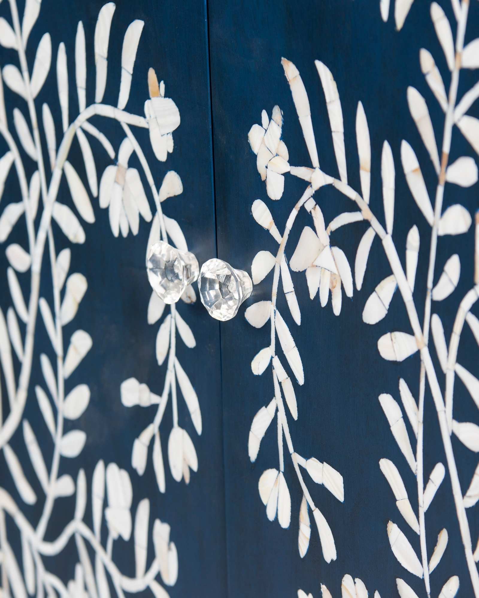 Mother of pearl inlay cabinet featuring intricate floral vine pattern in blue and white, handcrafted furniture piece.