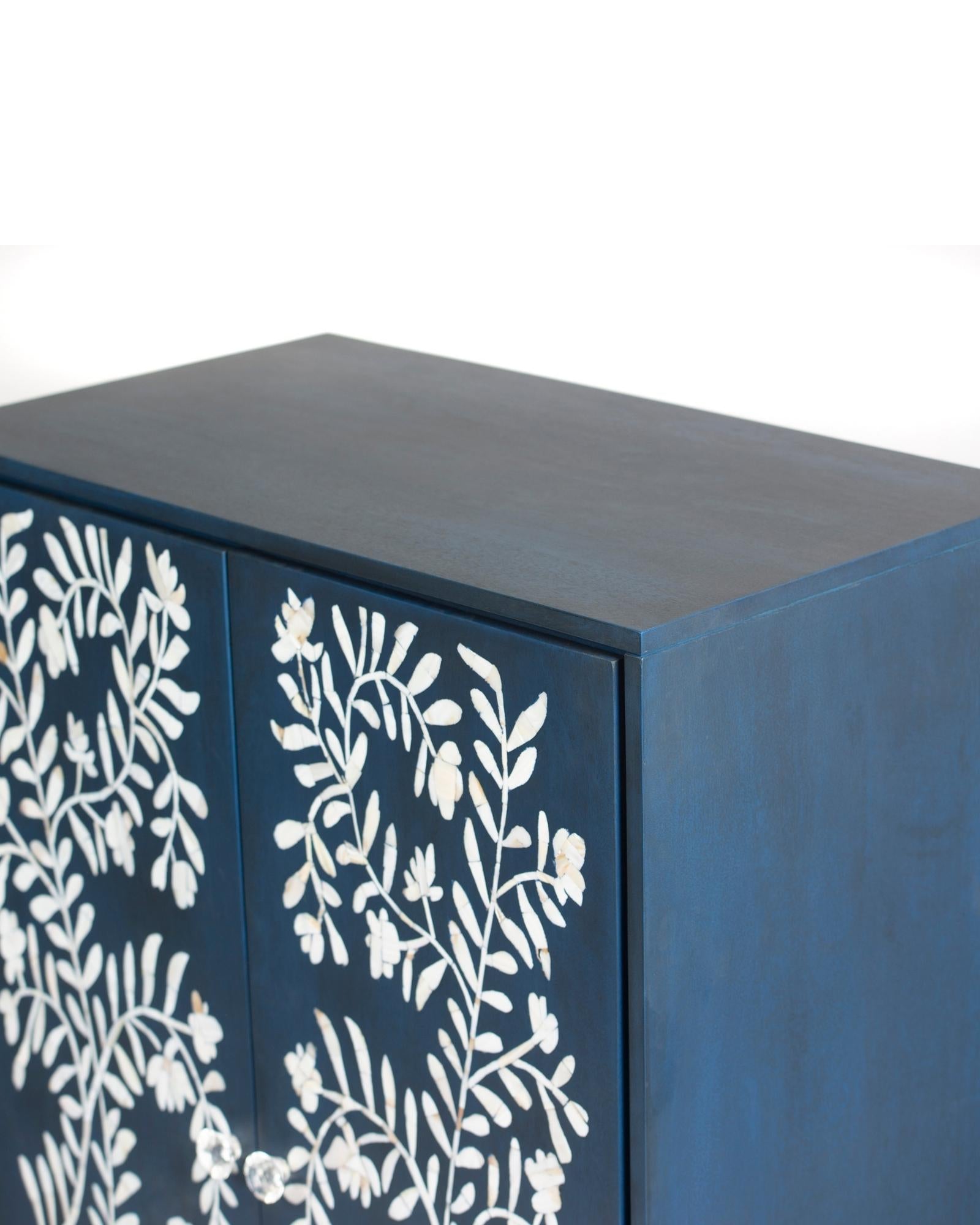 Mother of pearl inlay cabinet featuring intricate floral vine pattern in blue and white, handcrafted furniture piece.