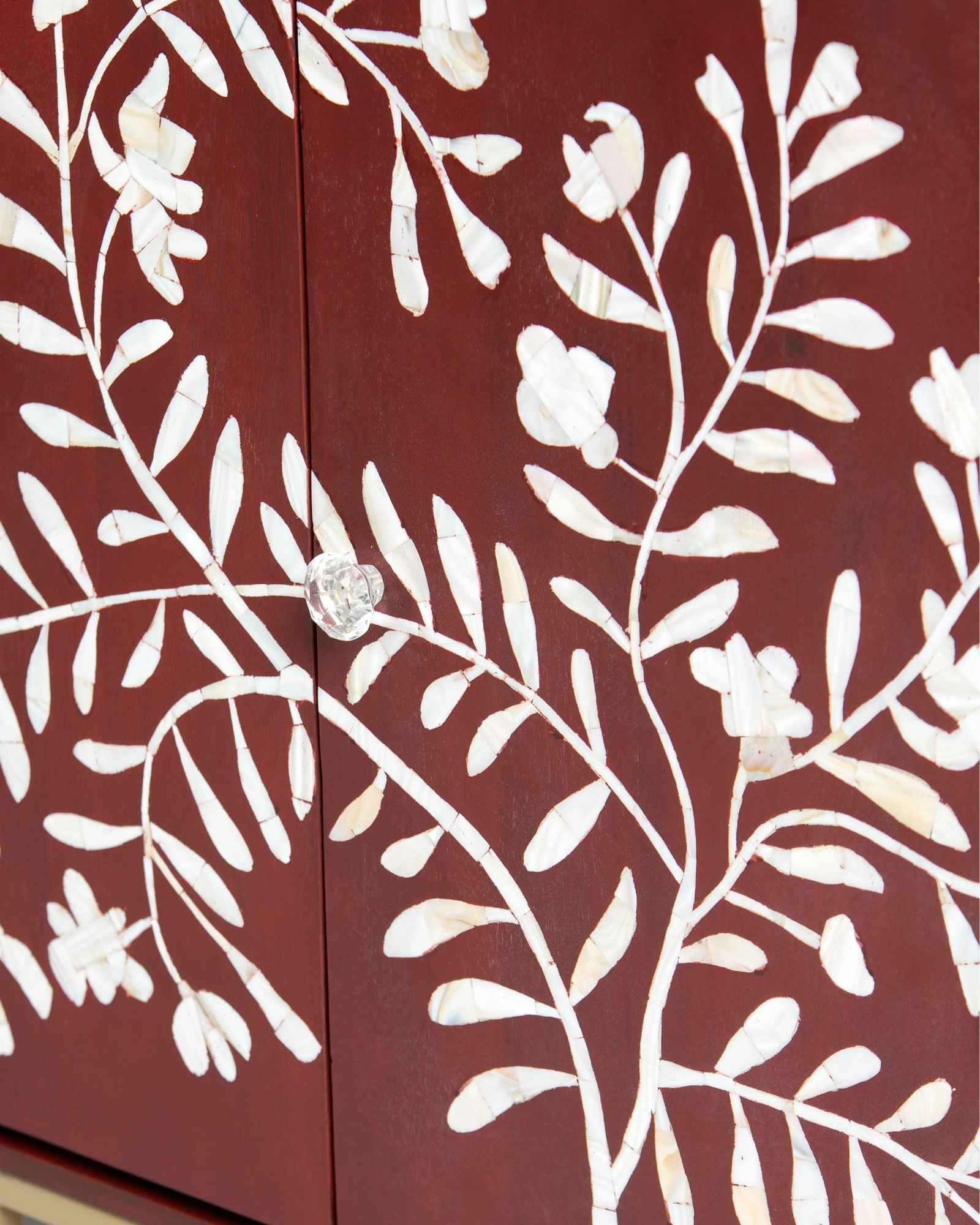 Mother of pearl inlay cabinet featuring intricate floral vine pattern in burgundy and white, handcrafted furniture piece.