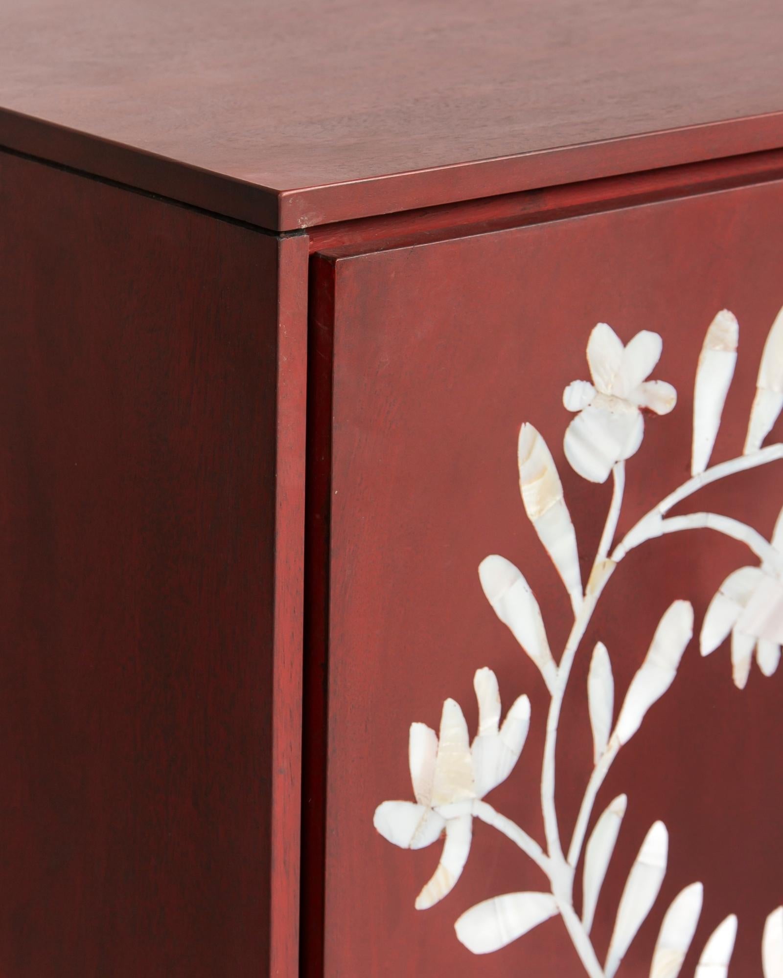 Mother of pearl inlay cabinet featuring intricate floral vine pattern in burgundy and white, handcrafted furniture piece.
