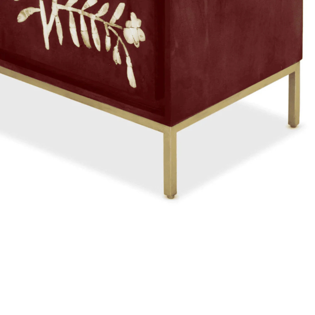 Handcrafted burgundy cabinet featuring intricate mother-of-pearl inlay, a floral pattern, and modern metal legs. A luxurious and functional storage piece.
