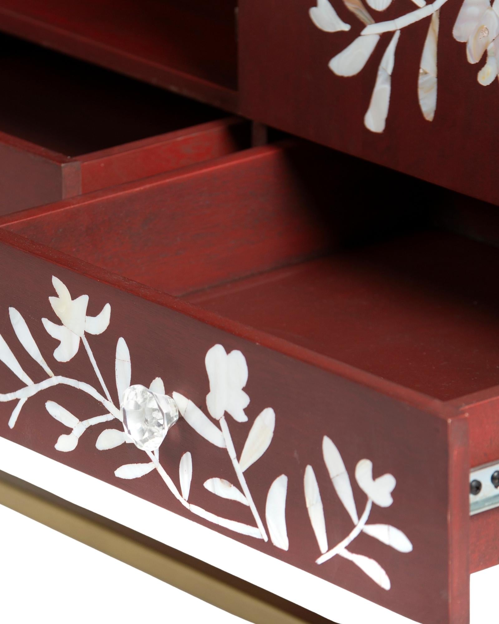 Mother of pearl inlay cabinet featuring intricate floral vine pattern in burgundy and white, handcrafted furniture piece.
