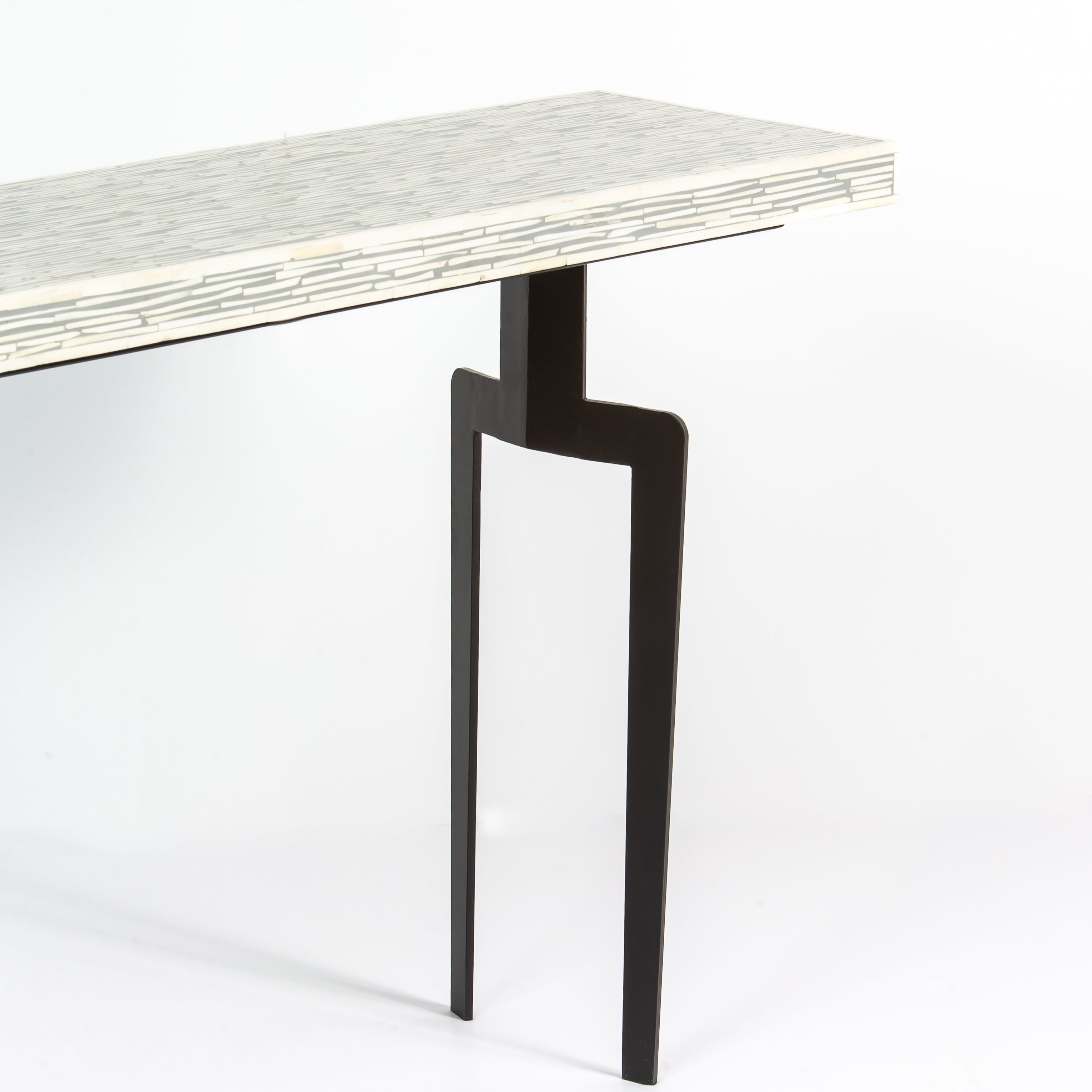 Table with a bone inlay top and black legs on a white background