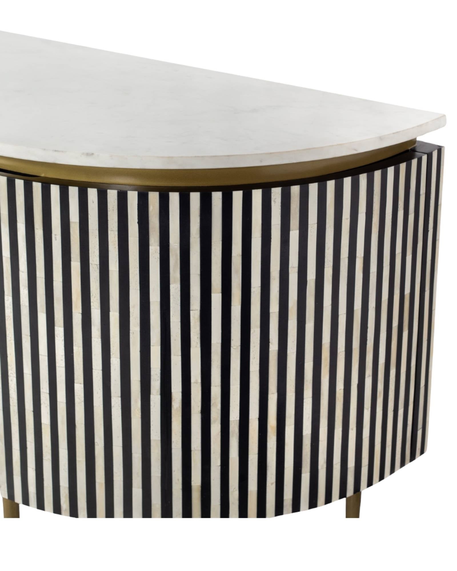 Black bone inlay sideboard with white marble top and brass legs, handcrafted with vertical striping and curved silhouette, luxury interior furniture.
