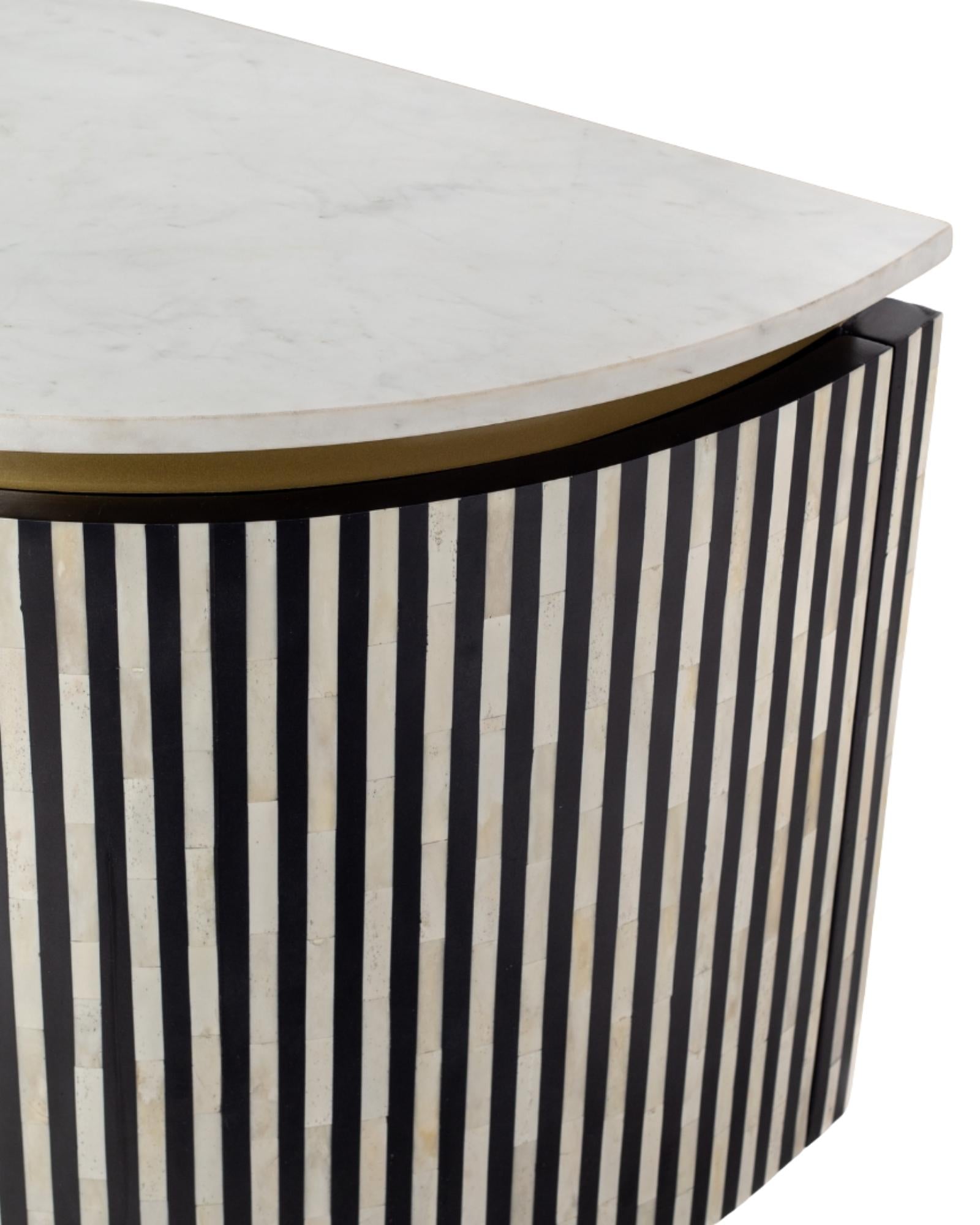 Black bone inlay sideboard with white marble top and brass legs, handcrafted with vertical striping and curved silhouette, luxury interior furniture.
