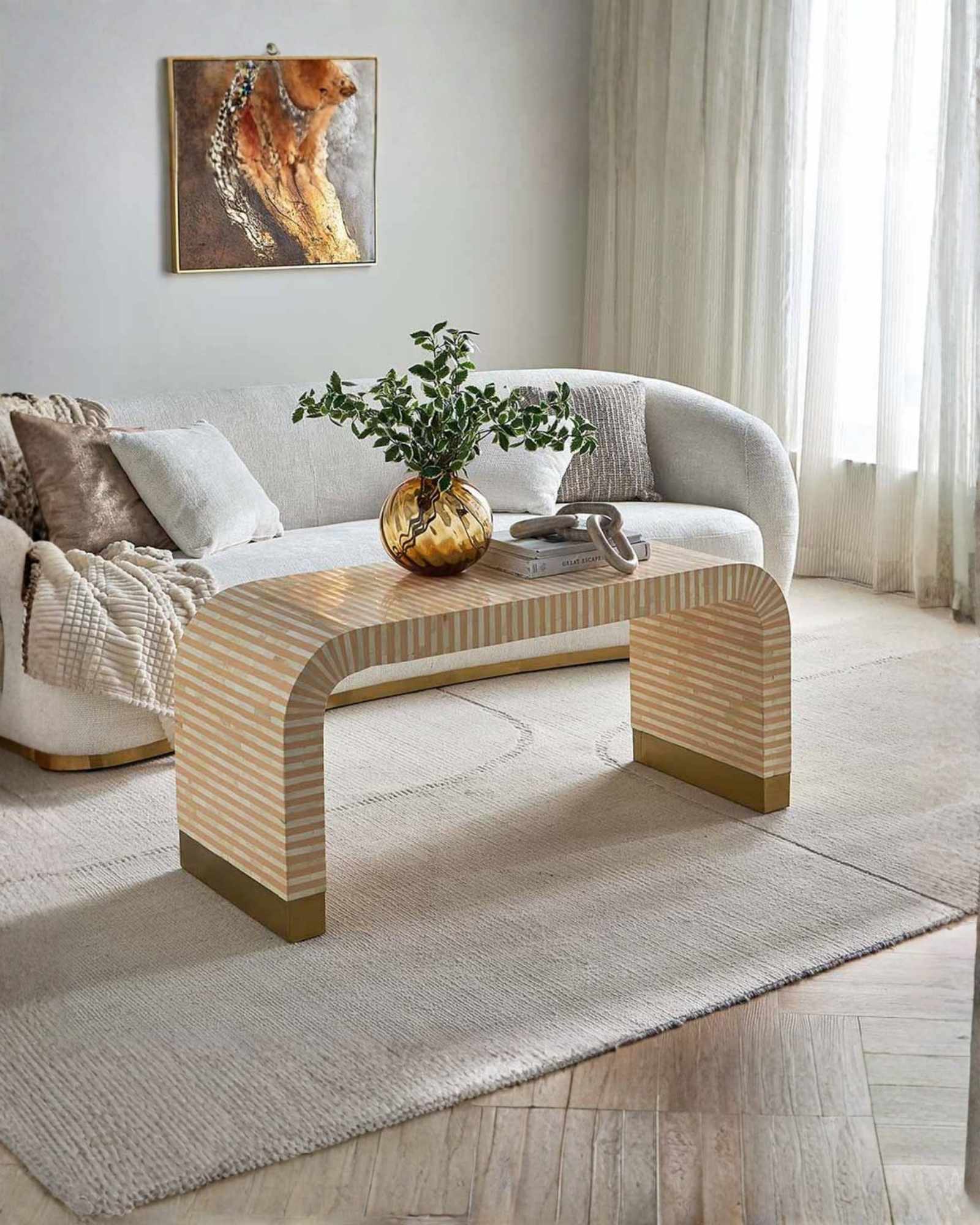 Modern beige bone inlay coffee table with curved edges and gold base. Features a striped inlay design for an elegant aesthetic.