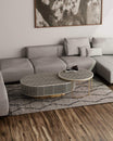 Saphed nesting coffee table set in black bone inlay, styled on a Berber rug in front of a grey sectional sofa.