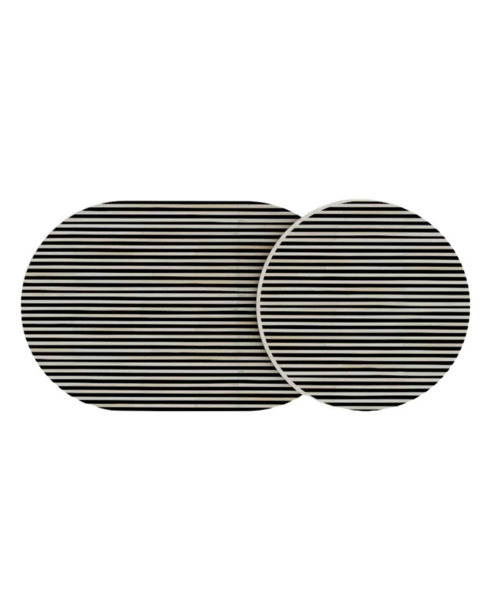 Black bone inlay nesting coffee table with vertical striped pattern and gold base, styled in a modern living room.
