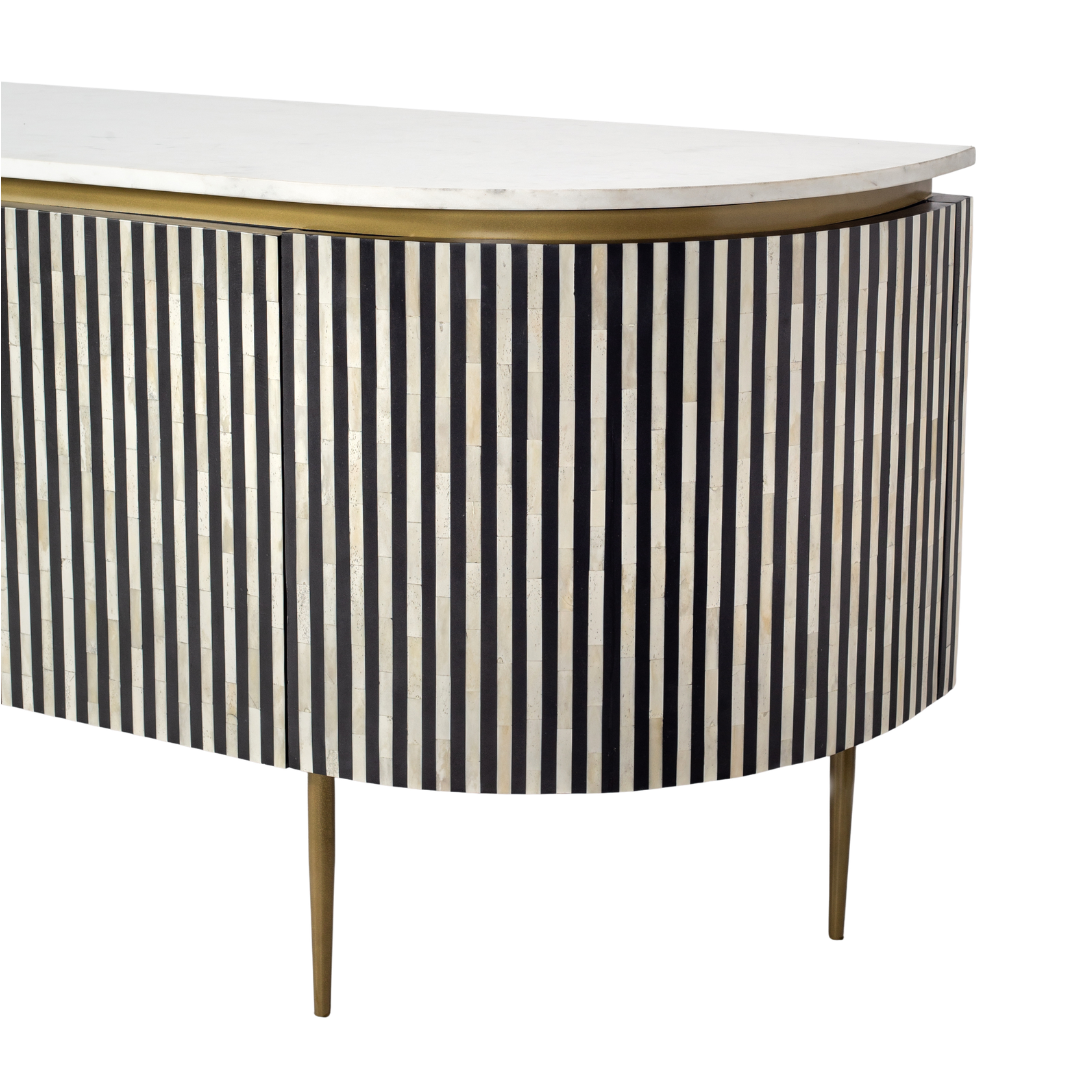 Black bone inlay sideboard with white marble top and brass legs, handcrafted with vertical striping and curved silhouette, luxury interior furniture.
