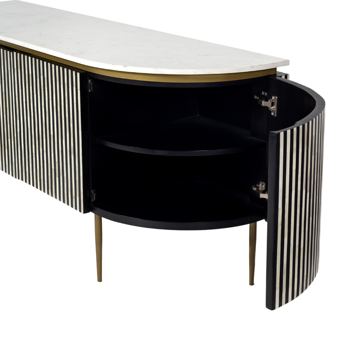 Black bone inlay sideboard with white marble top and brass legs, handcrafted with vertical striping and curved silhouette, luxury interior furniture.

