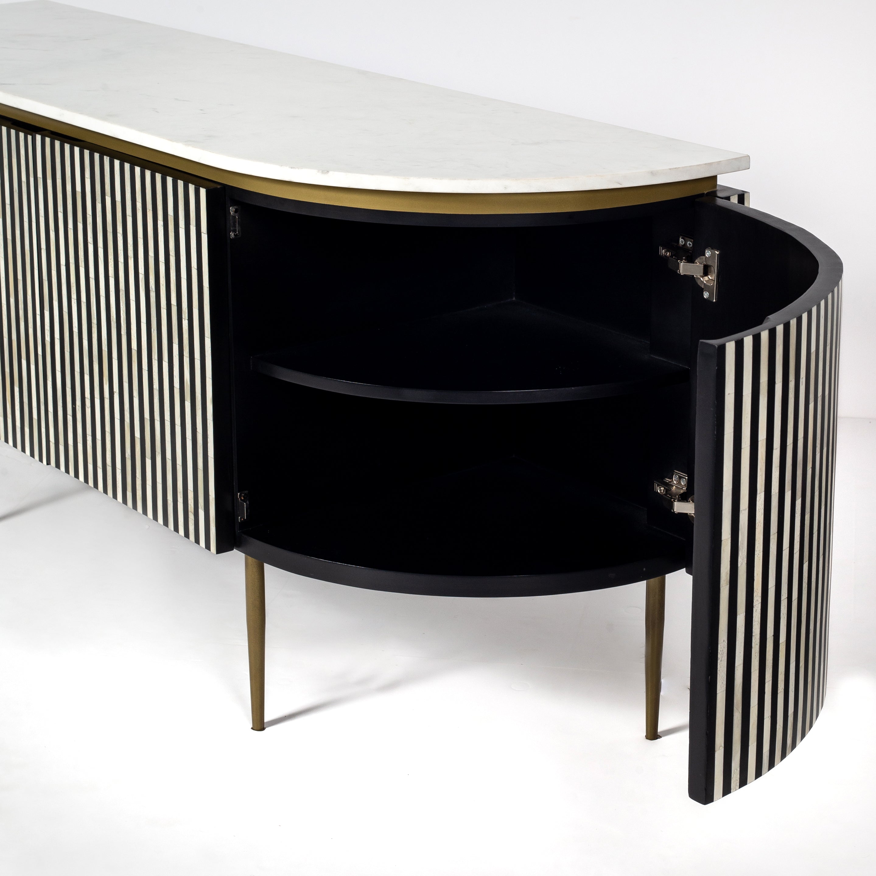 Black bone inlay sideboard with white marble top and brass legs, handcrafted with vertical striping and curved silhouette, luxury interior furniture.

