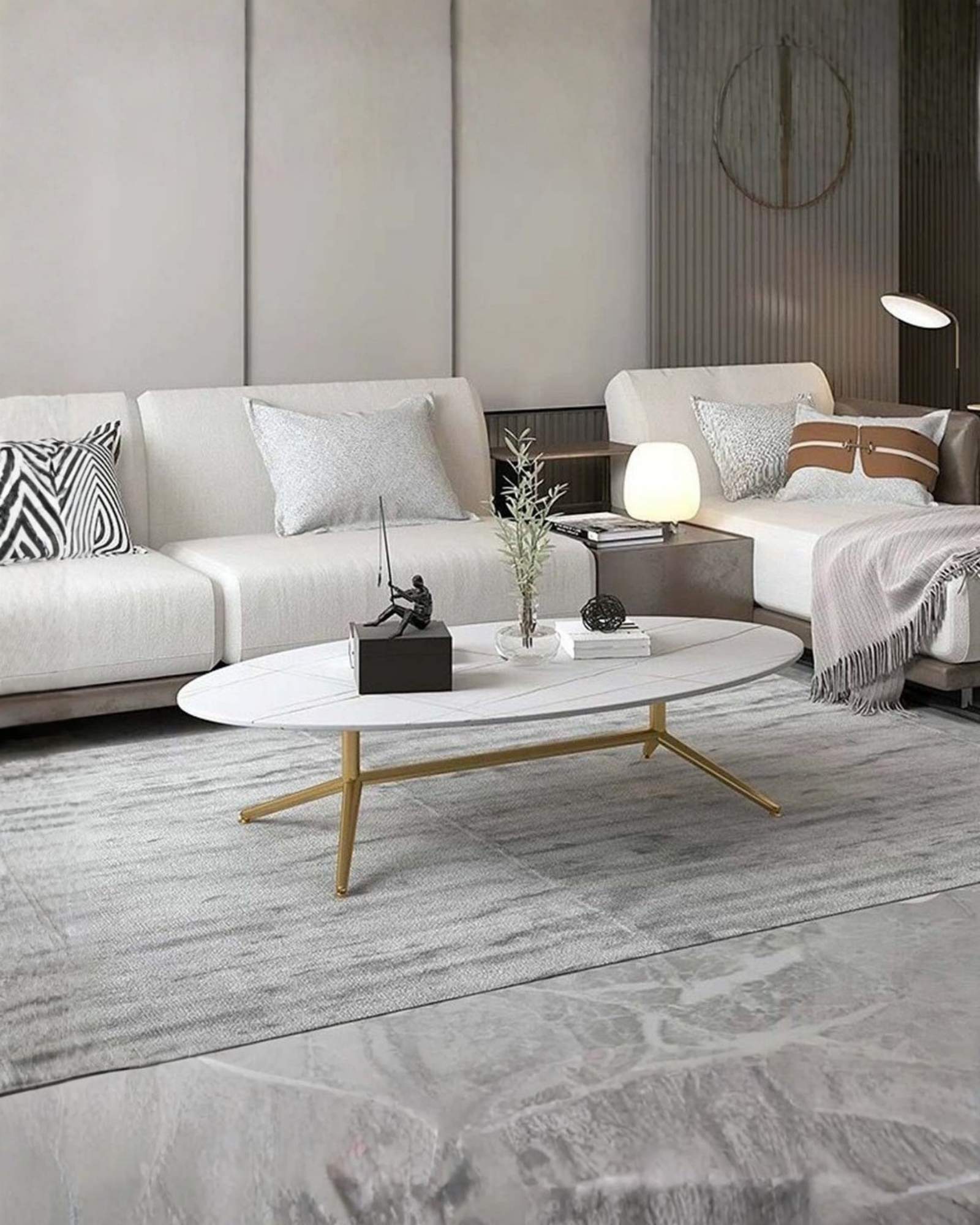 Oval white marble coffee table with subtle gold vein detailing and sleek gold legs. A modern and elegant addition to any living space.