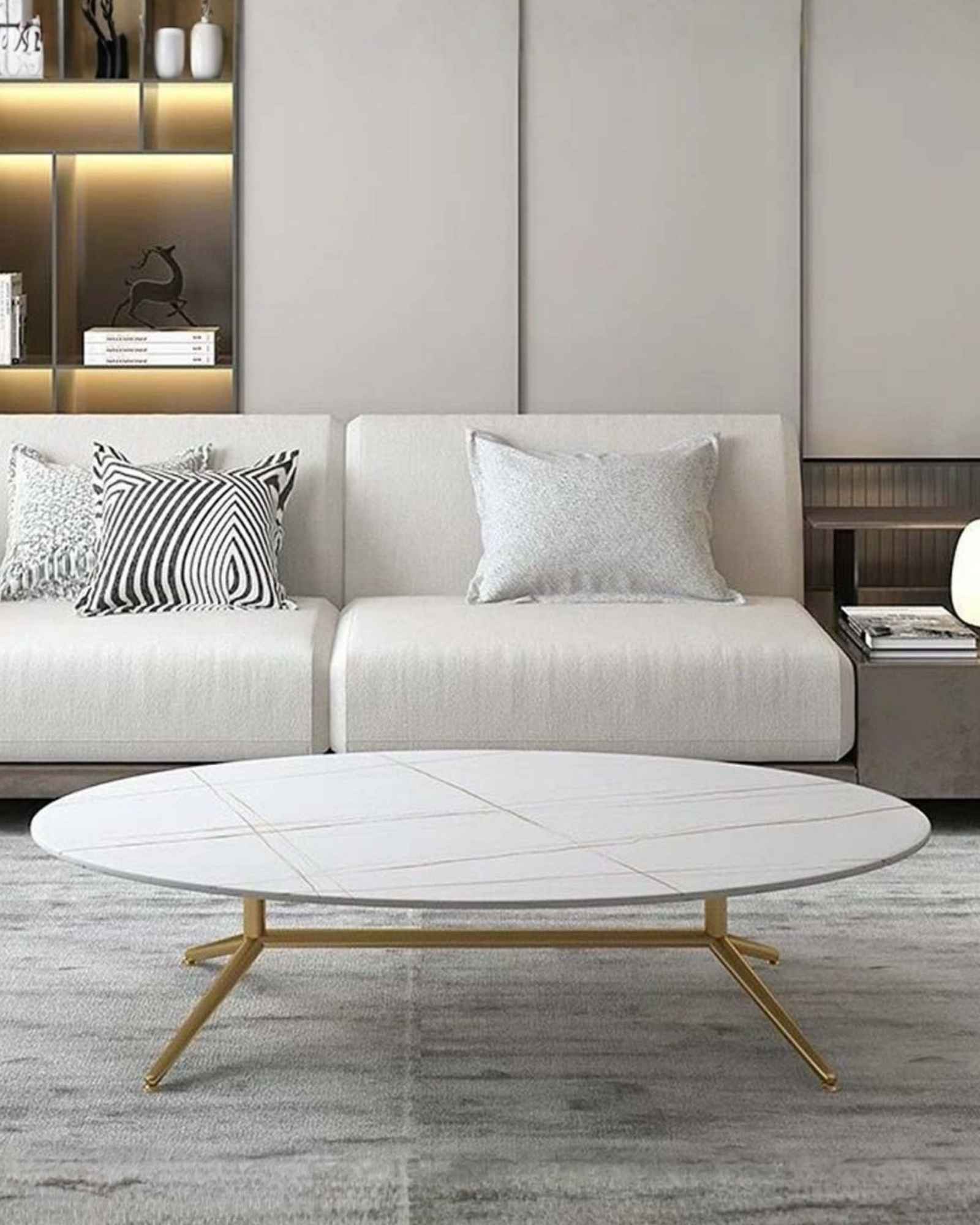 Oval white marble coffee table with subtle gold vein detailing and sleek gold legs. A modern and elegant addition to any living space.