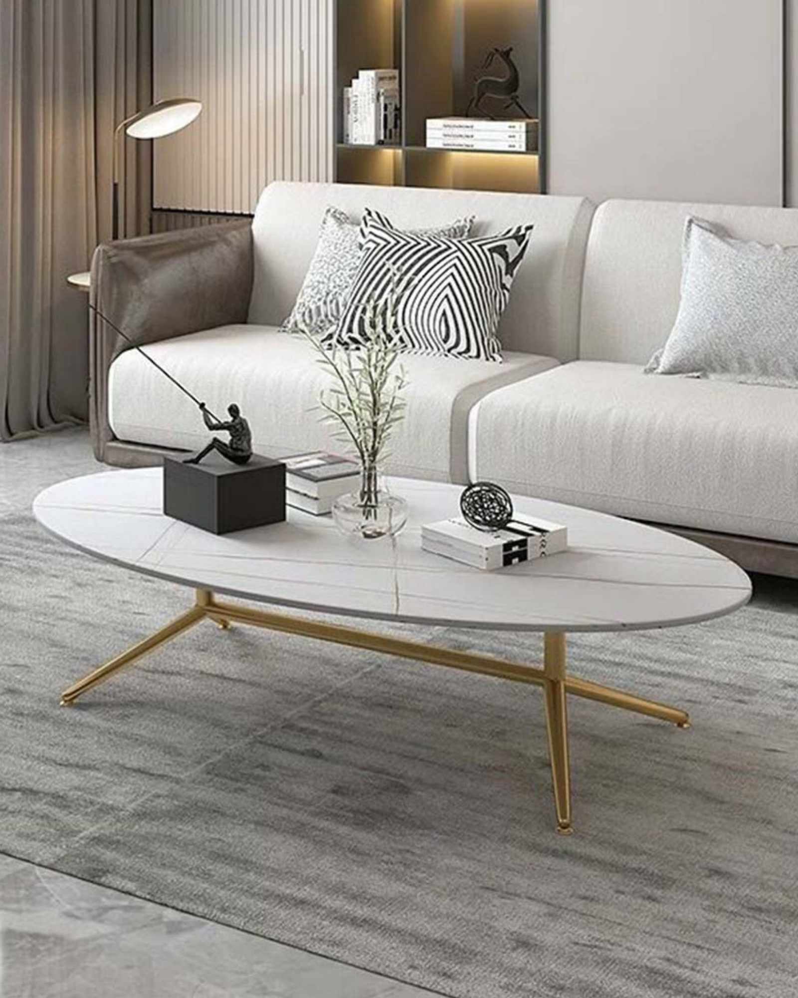 Oval white marble coffee table with subtle gold vein detailing and sleek gold legs. A modern and elegant addition to any living space.