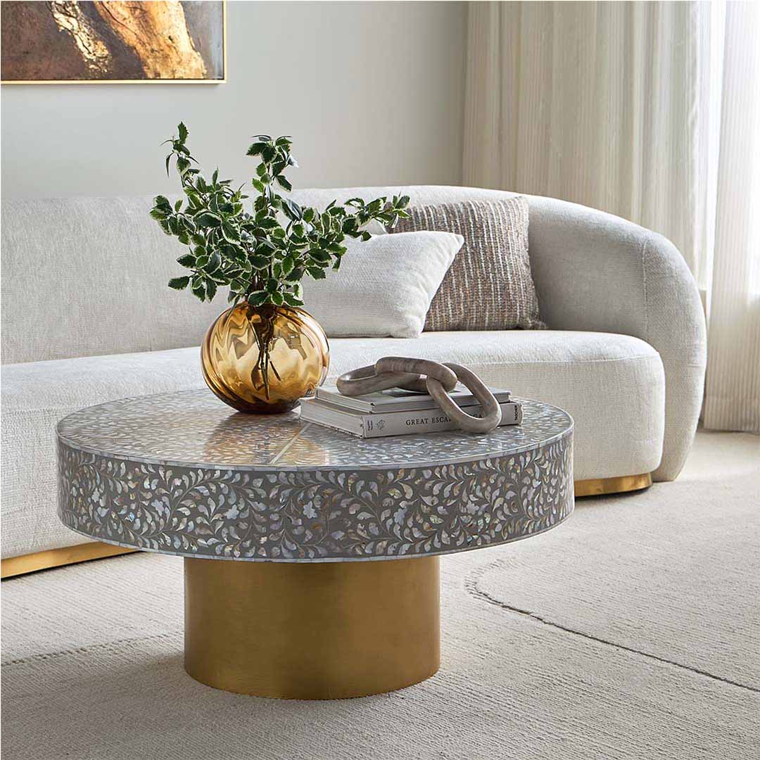 Round grey mother of pearl inlay coffee table with intricate floral design and a gold cylindrical metallic base.