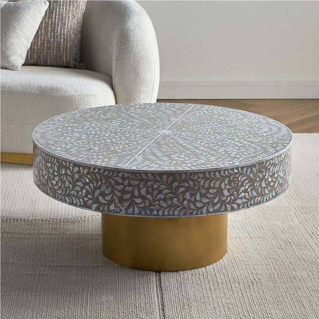 Round grey mother of pearl inlay coffee table with intricate floral design and a gold cylindrical metallic base.