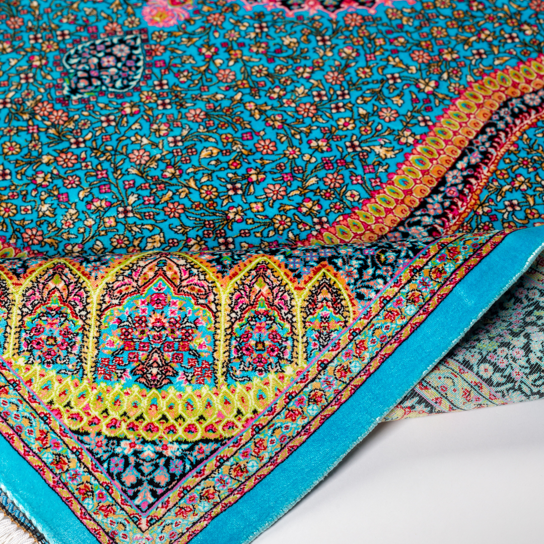 Vortex Silk Rug featuring a central floral medallion on a turquoise base with red, green, and black detailing, size 150x100 cm.