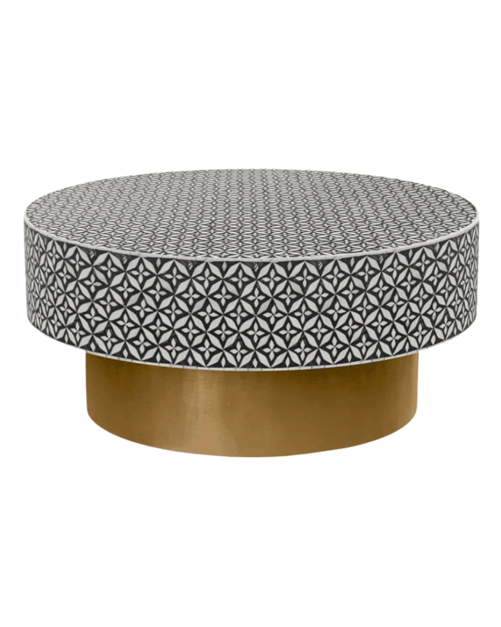 Round black bone inlay coffee table with intricate floral pattern and bold gold base. A modern, stylish centerpiece for any room.