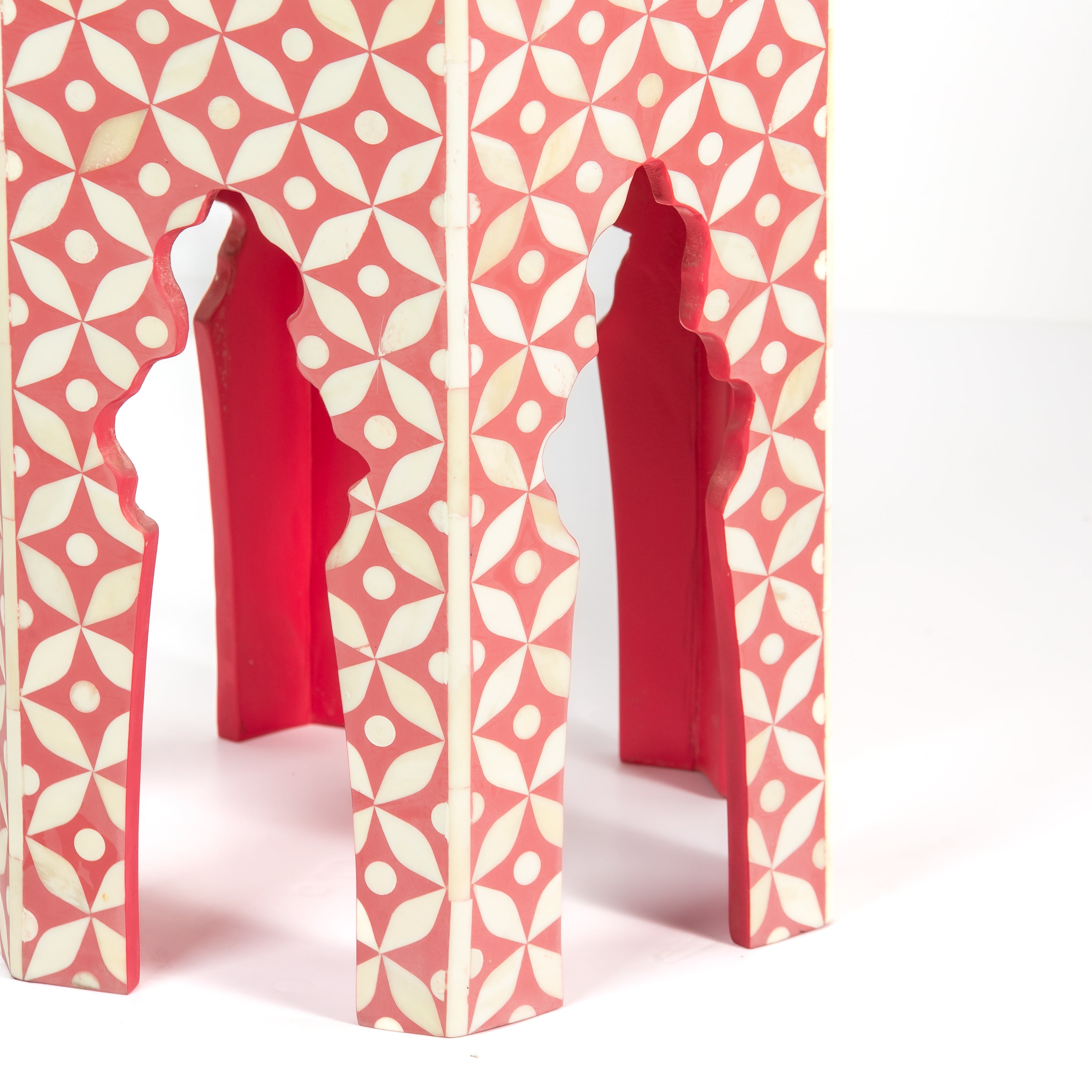 Handcrafted Yasmine side table featuring pink bone inlay with a hexagonal silhouette, geometric detailing, and arched legs.