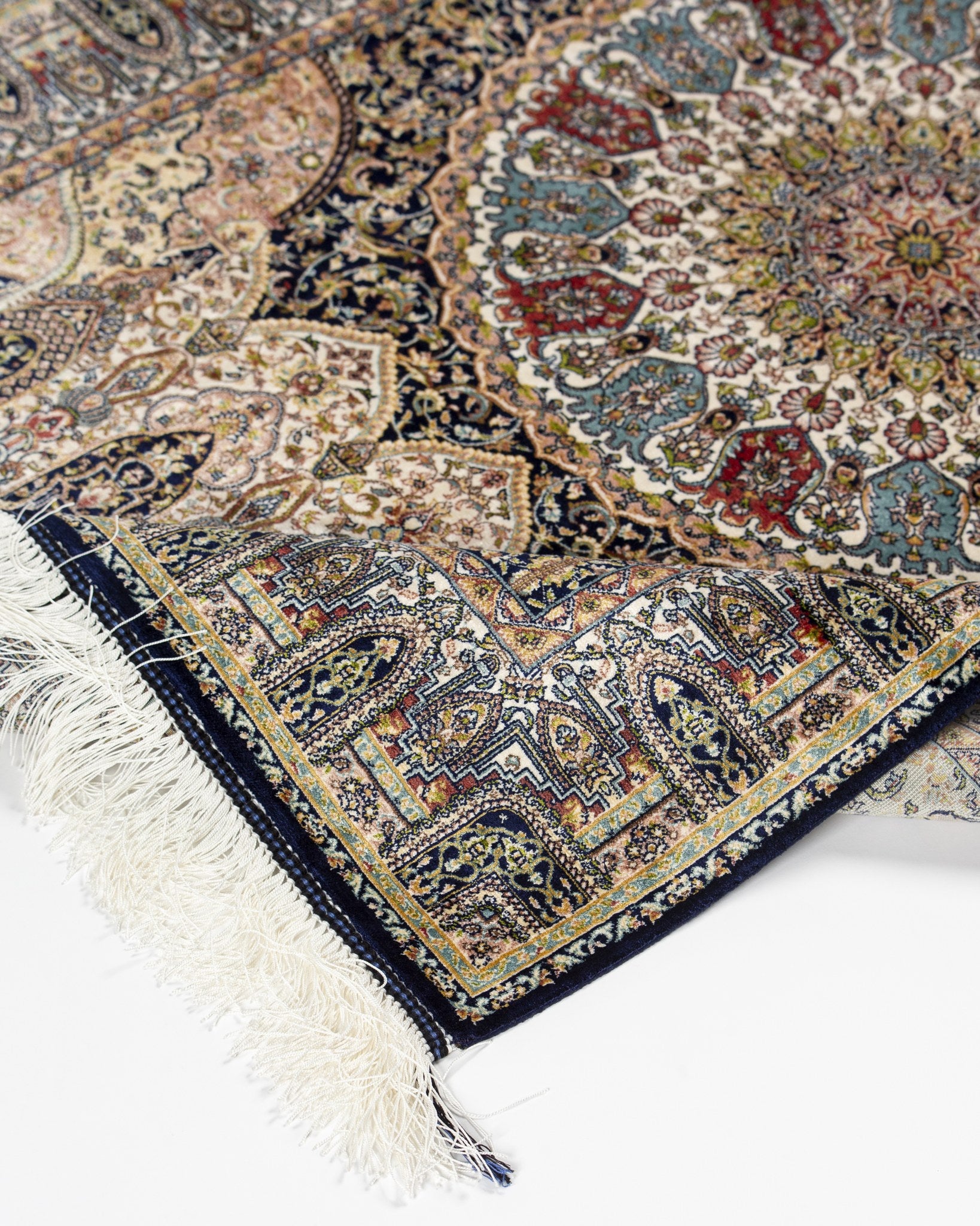 Angled view of the Anahita silk rug with fringed end