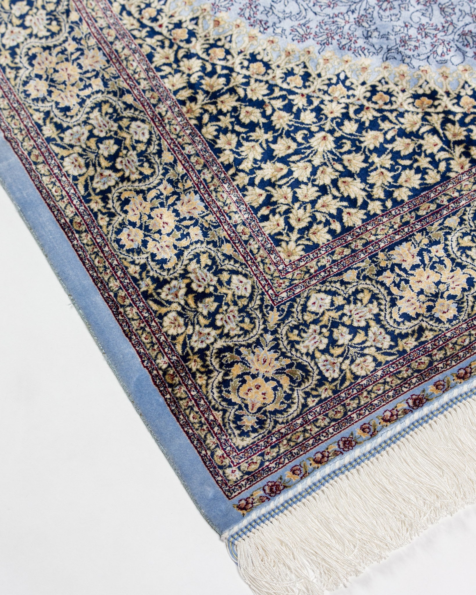 Corner and border of the Aseman blue silk rug with silk fringe