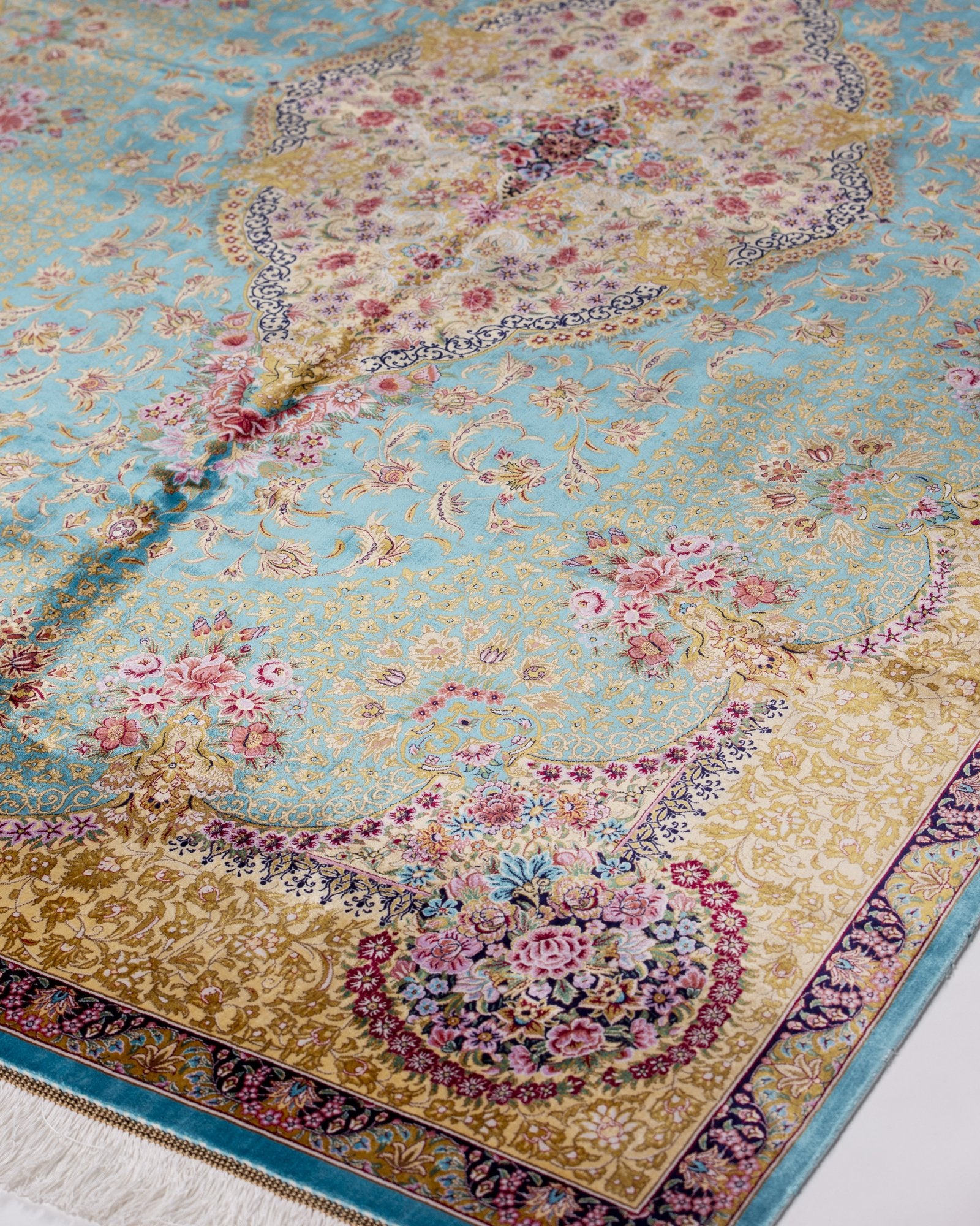 angled view with a fringed end on the Aurelia teal silk rug