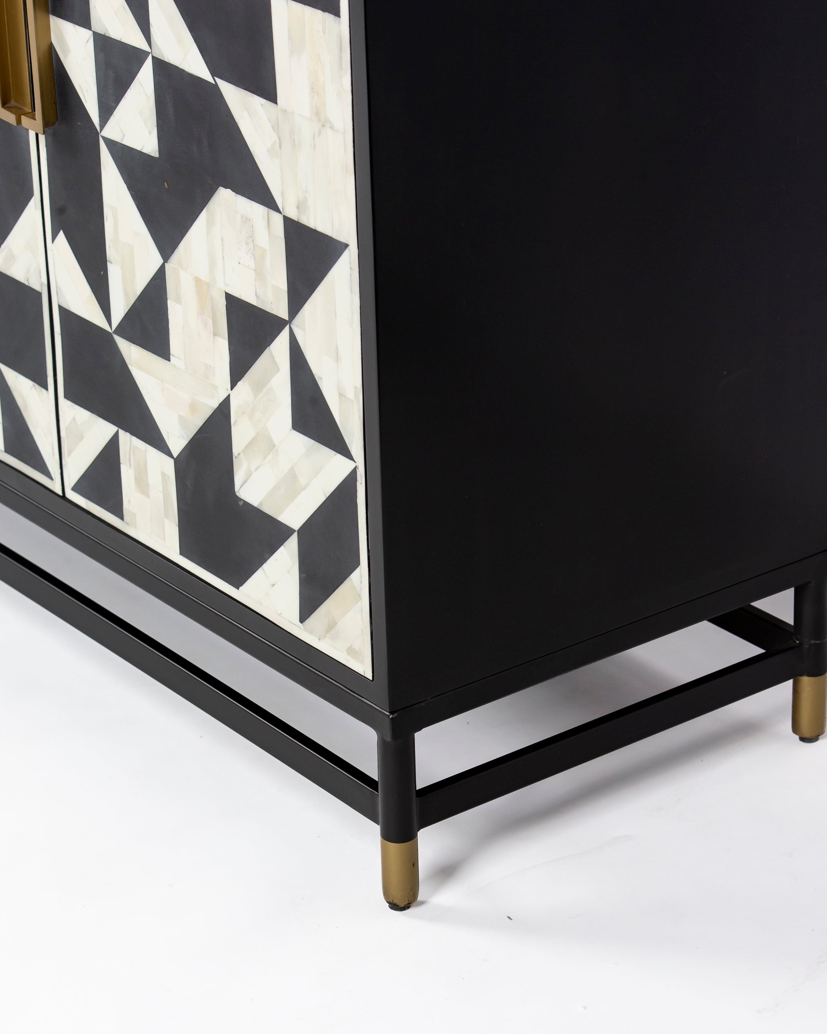 Black metal base with brass tipped feet on Eve cabinet