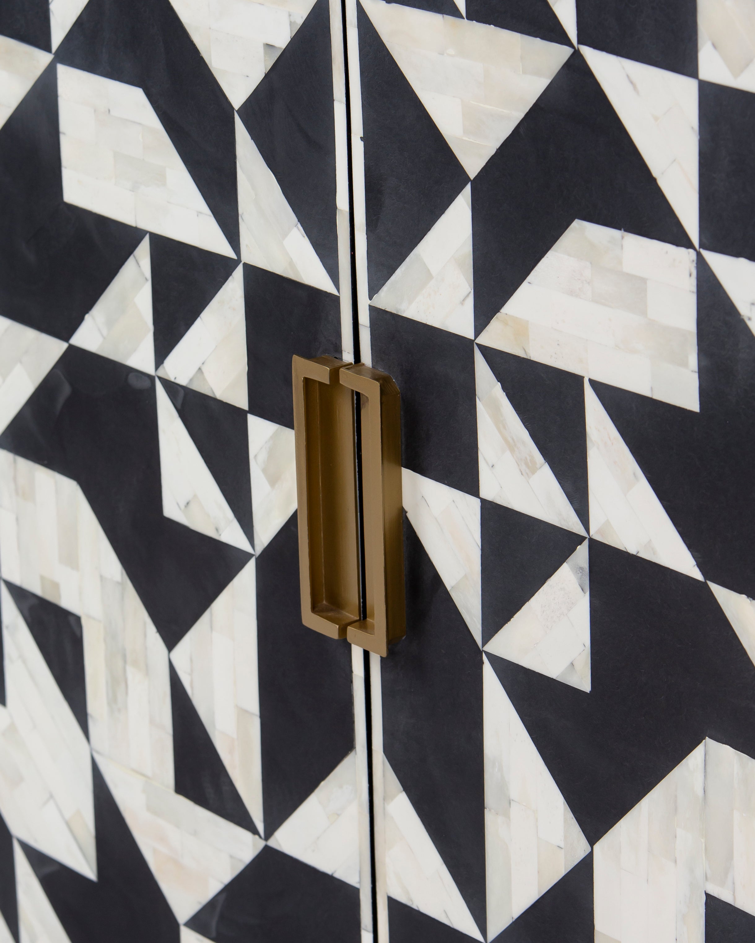 Brass recessed handle detail on black and white bone inlay doors