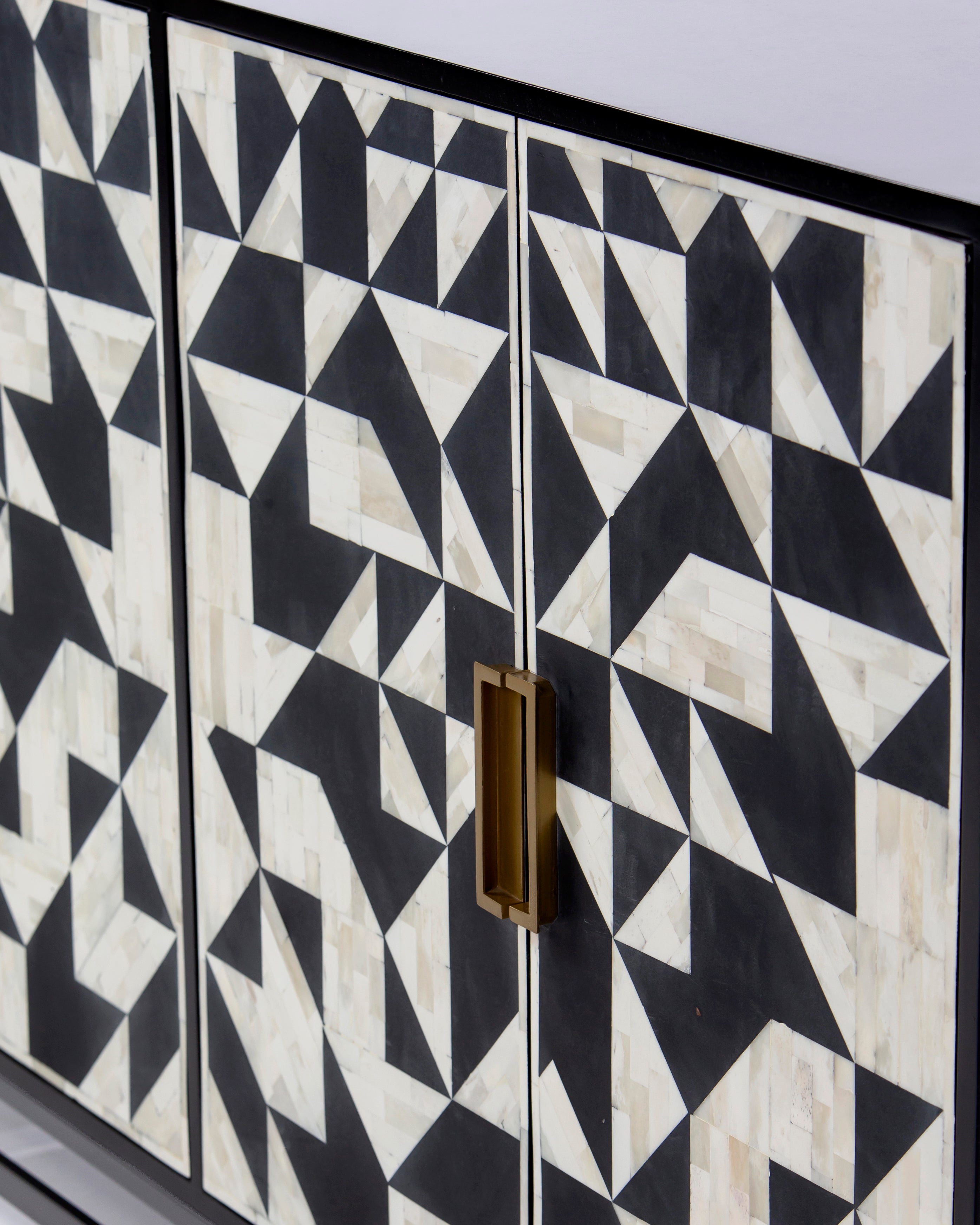 Recessed brass handle on geometric bone inlay door of Eve sideboard