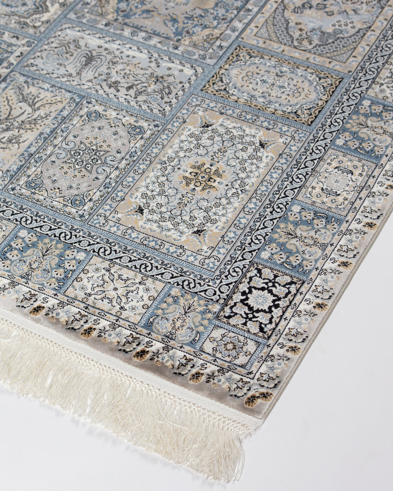 Angled view of the Golestan silk rug panels with silk fringe