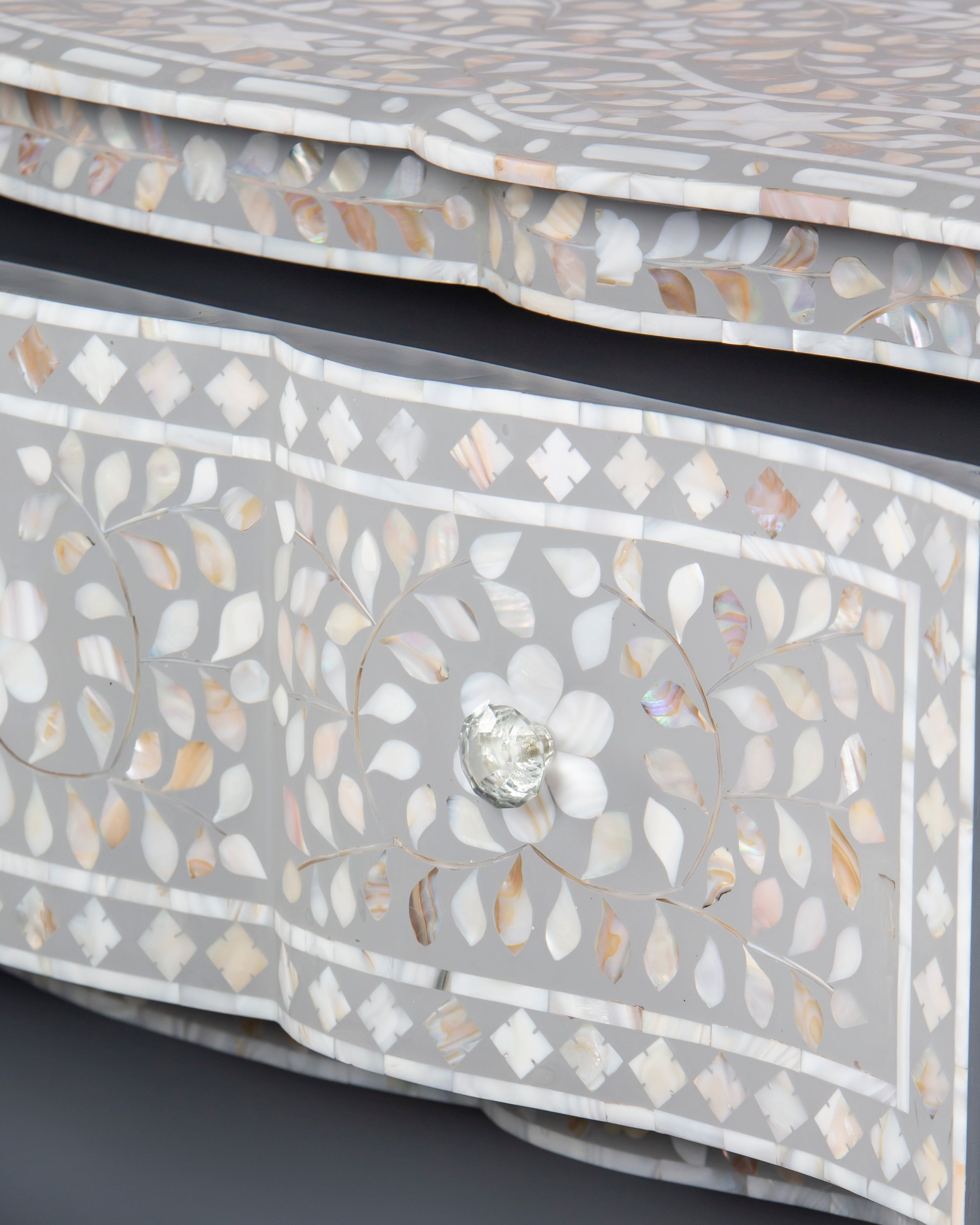 Close up of handcrafted mother of pearl floral inlay and crystal knob