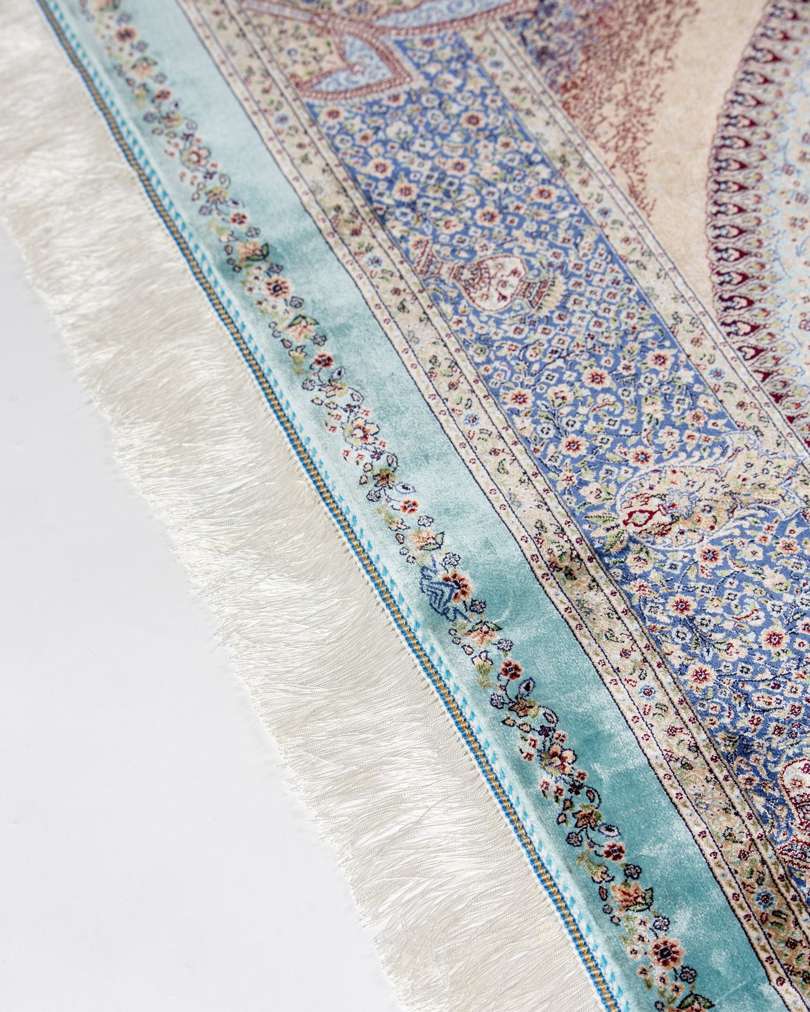 angled view with a fringed end on the Nasrin blue silk rug