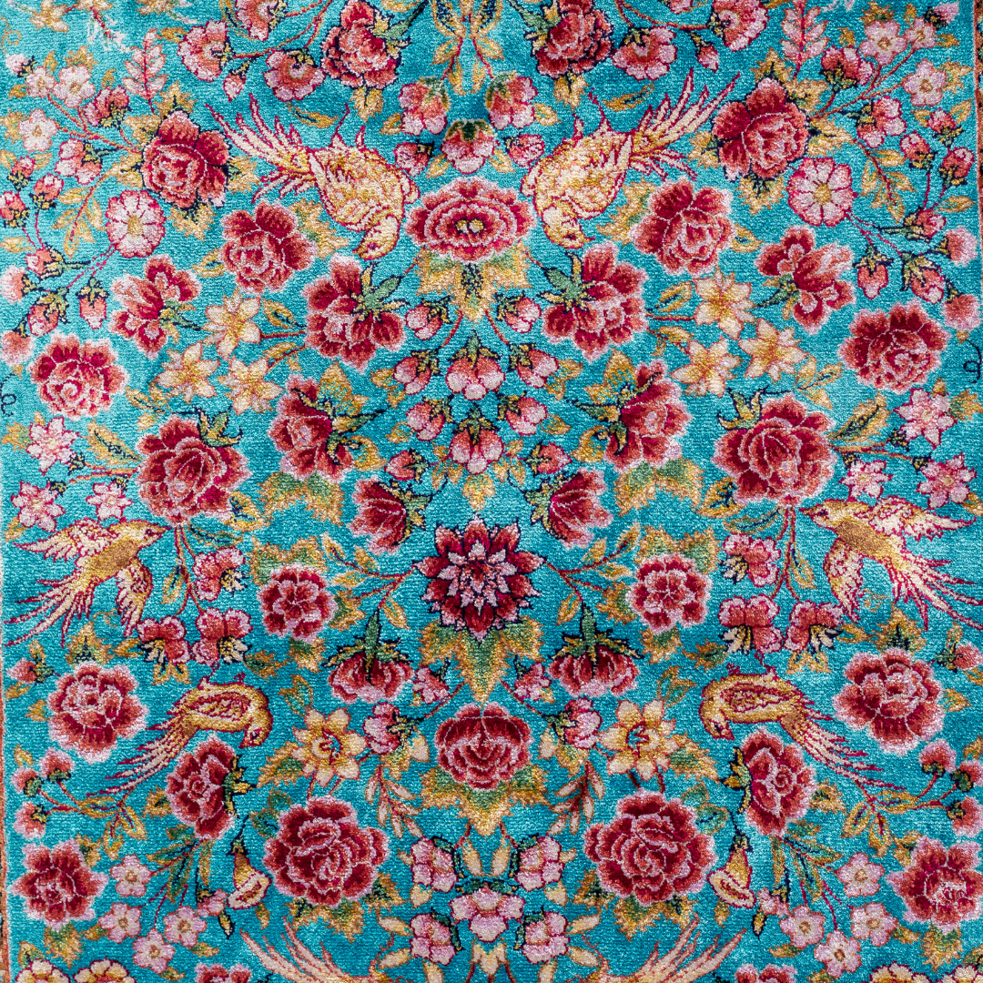 Neriah Silk Rug featuring ruby red floral and bird motifs on an aqua-blue base with golden ornate panels, size 150x100 cm.