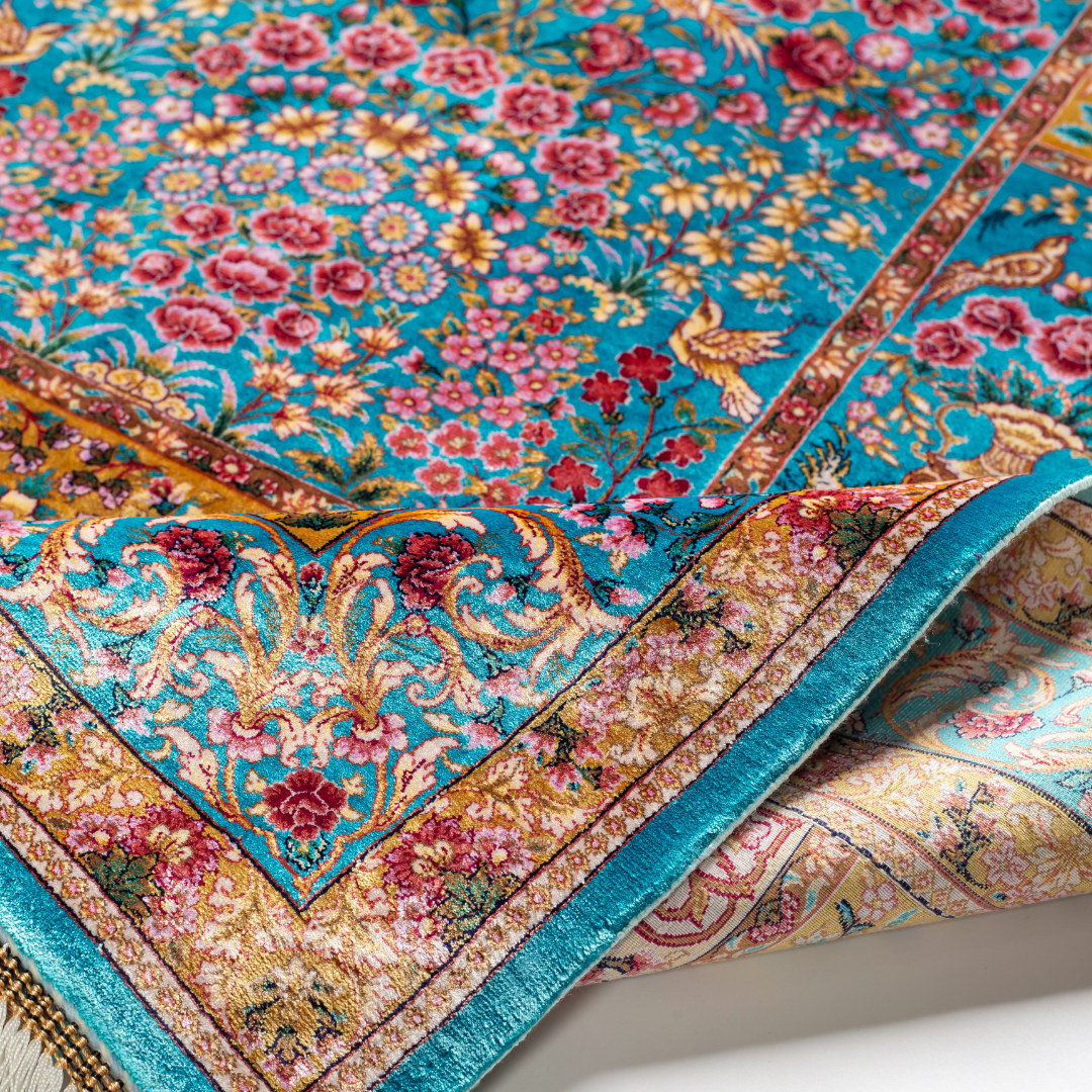 Neriah Silk Rug featuring ruby red floral and bird motifs on an aqua-blue base with golden ornate panels, size 150x100 cm.