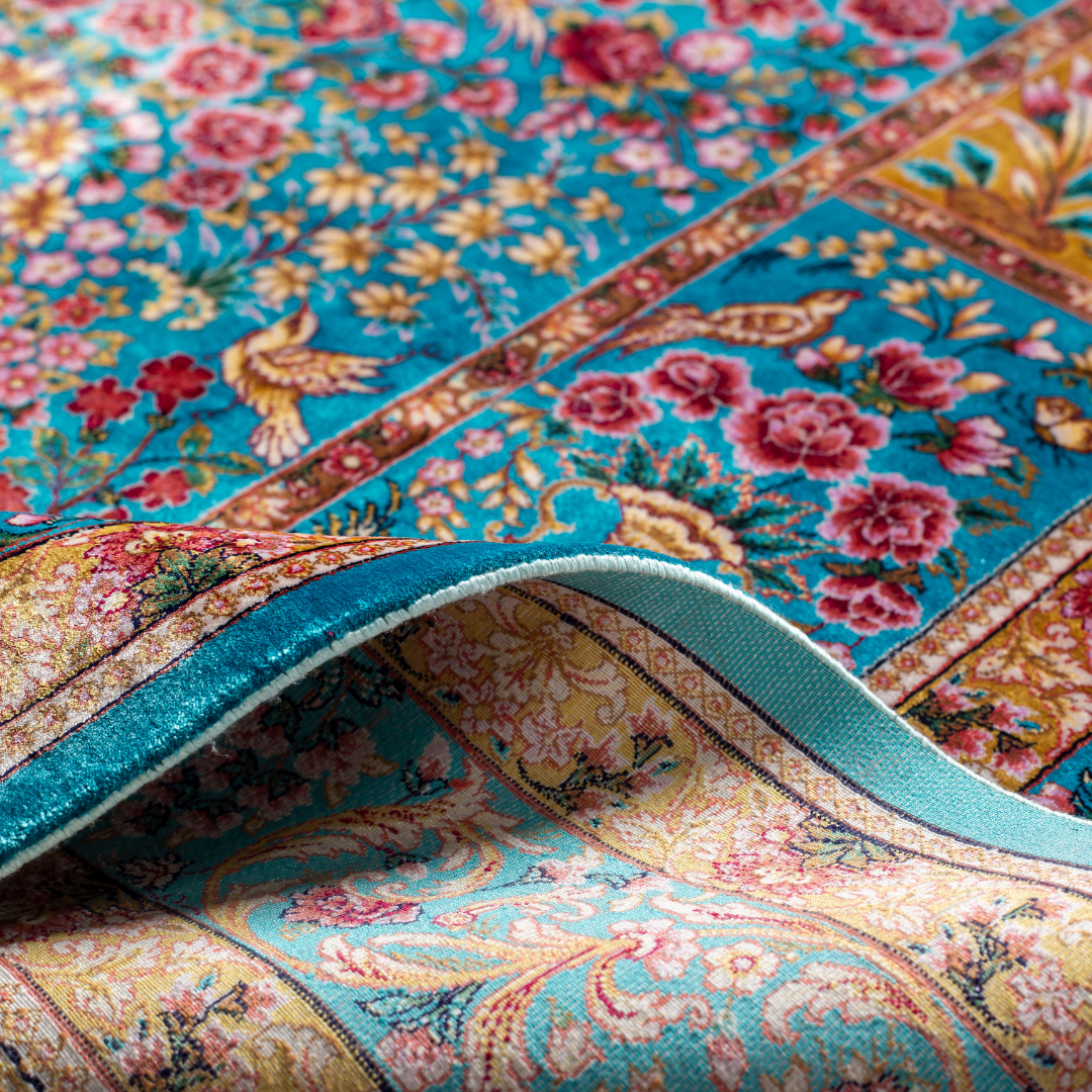 Neriah Silk Rug featuring ruby red floral and bird motifs on an aqua-blue base with golden ornate panels, size 150x100 cm.