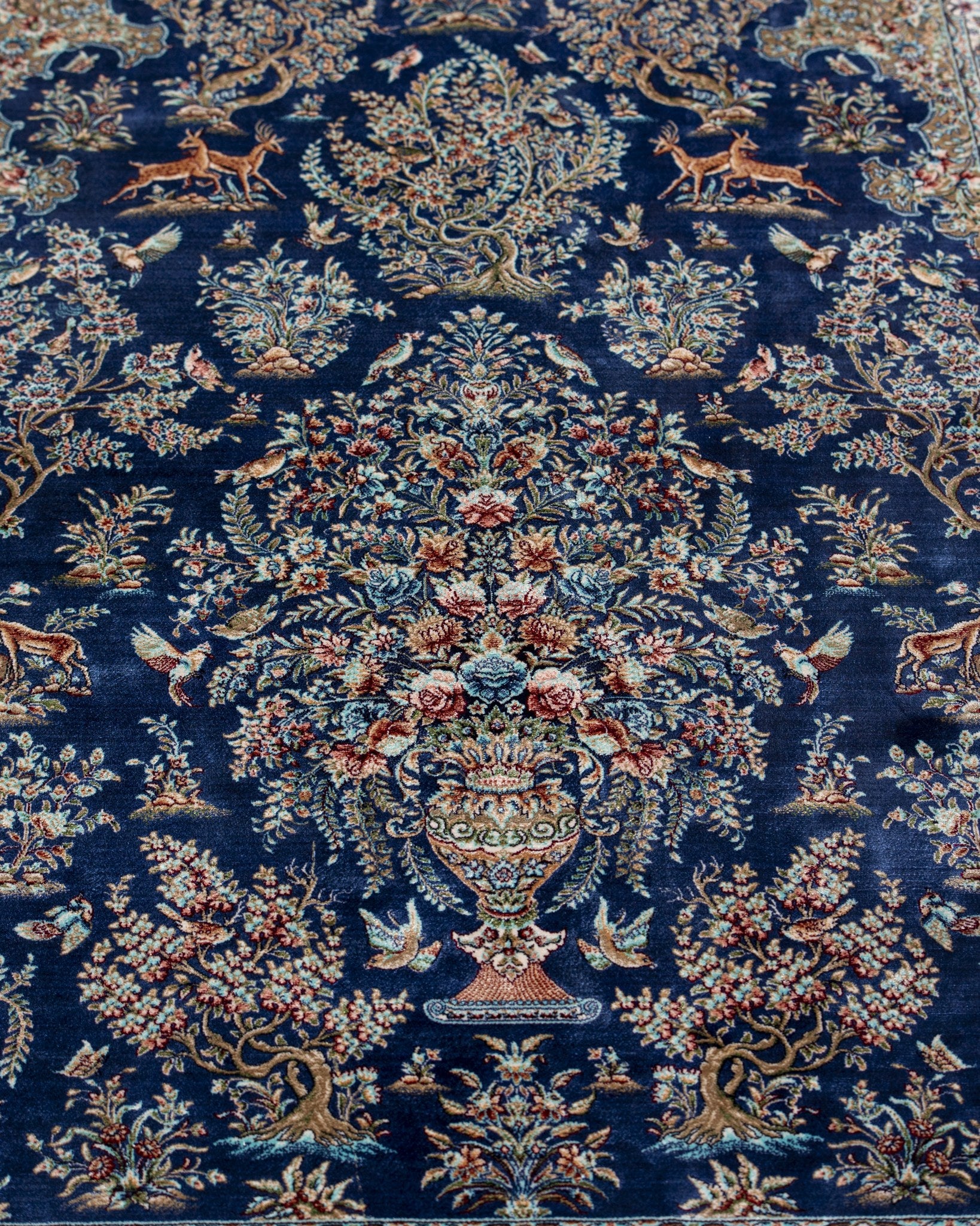 Full view of the Nilofar blue silk rug showing its cornflower blue field and floral vase design