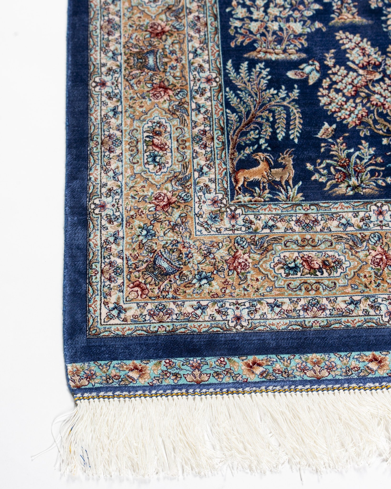 Corner of the Nilofar silk rug with soft ivory border and silk fringe
